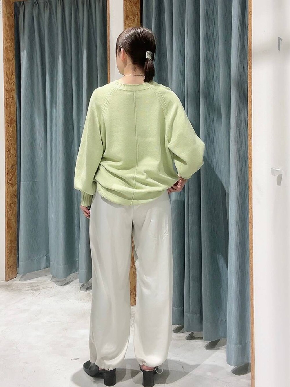 ホワイト系のその他パンツ、ブラック系のパンプス、グリーン系のニット/セーターを着用したレディースの冬コーディネートの3枚目の写真