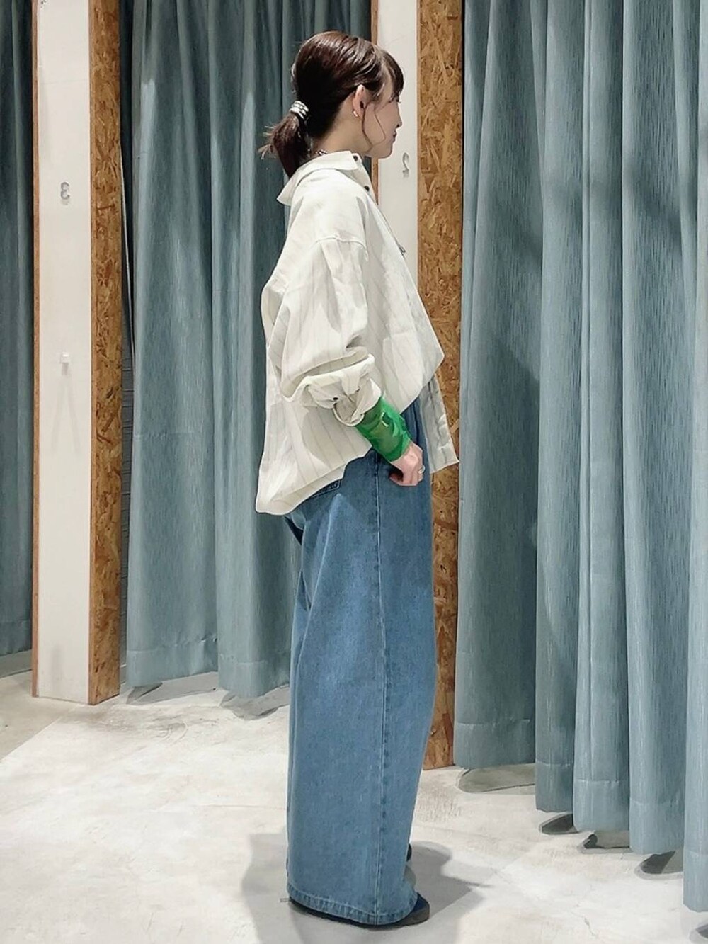 ブルー系のスニーカー、ブラック系のTシャツ/カットソー、ブルー系のデニムパンツを着用したレディースの冬コーディネートの2枚目の写真