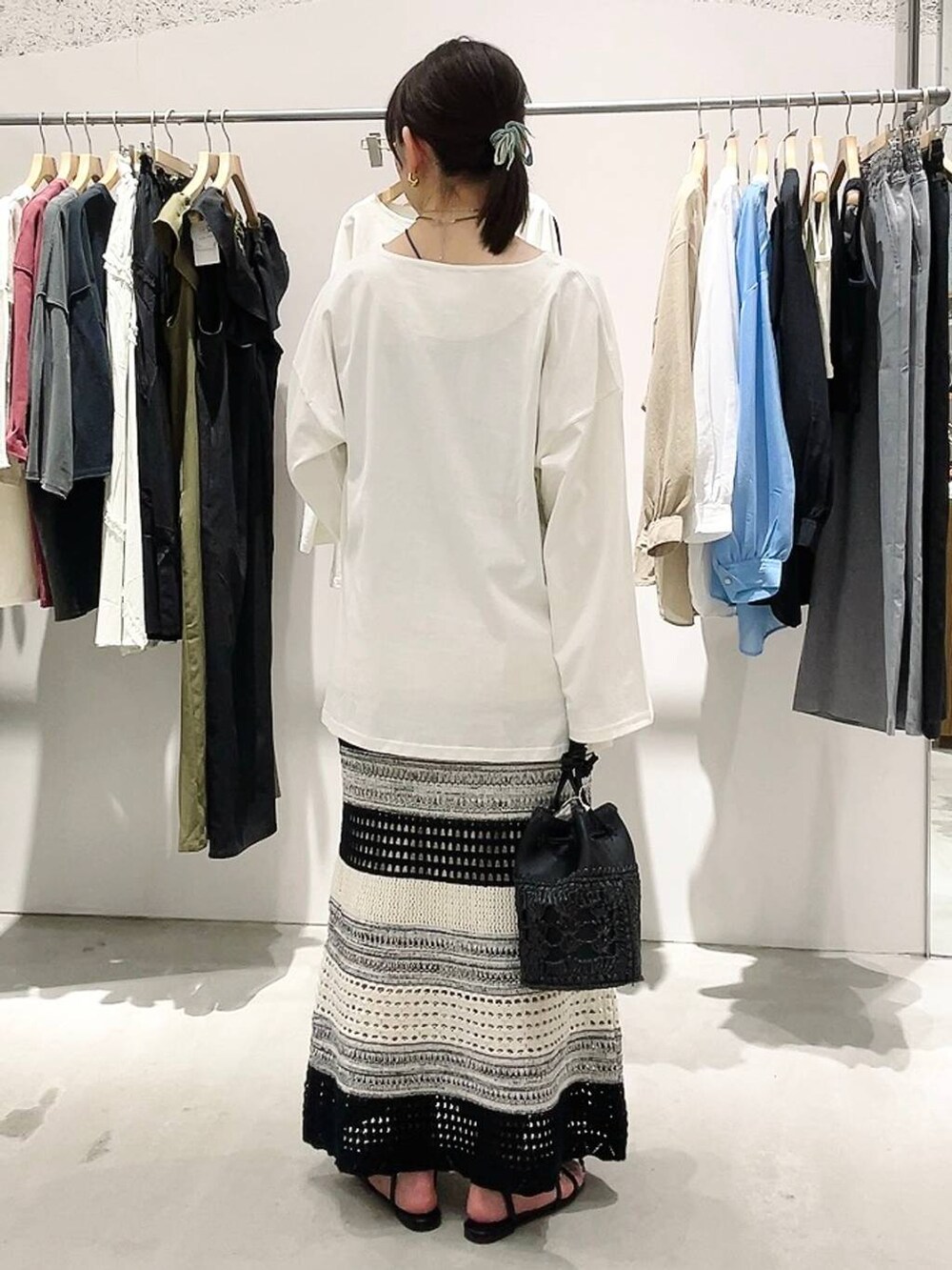 ホワイト系のTシャツ/カットソー、ブラック系のスカート、ブラック系のショルダーバッグを着用したレディースの春コーディネートの4枚目の写真