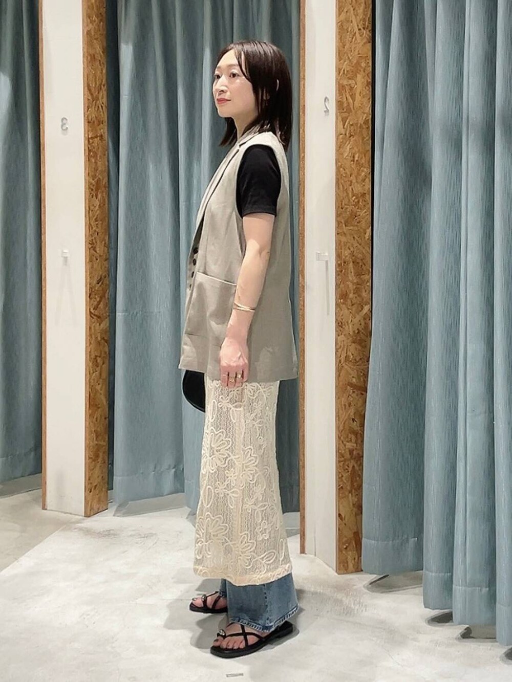 ブラック系のTシャツ/カットソー、ブラック系のハンドバッグ、ブラウン系のサンダルを着用したレディースの春コーディネートの6枚目の写真