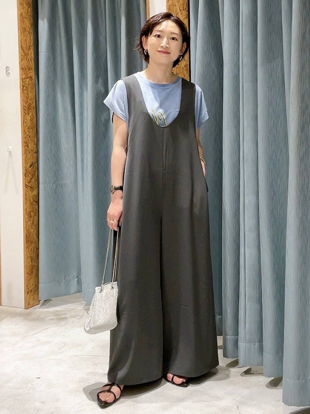 シルバー系のショルダーバッグ、ブラック系のサンダル、グレー系のサロペット/オーバーオールを着用したレディースの夏コーディネートの5枚目の写真