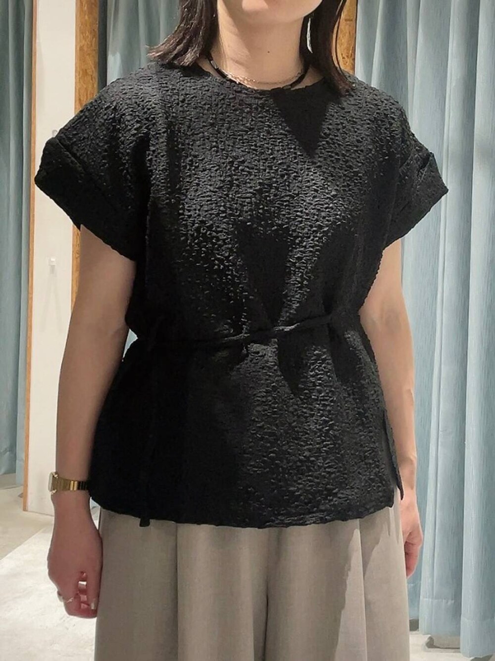 ブラウン系のサンダル、ベージュ系のその他パンツ、ブラック系のTシャツ/カットソーを着用したレディースの夏コーディネートの3枚目の写真