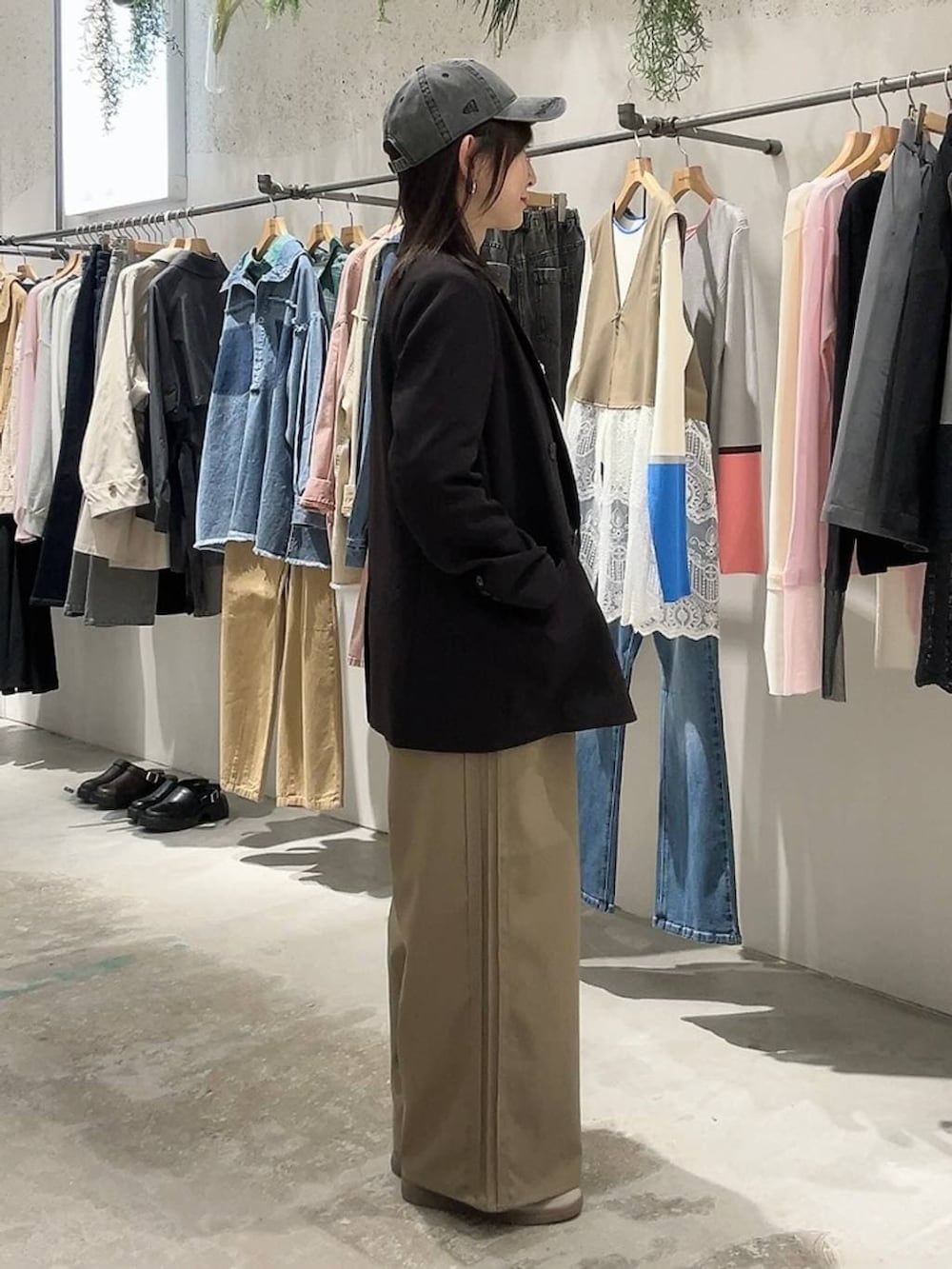 ブラック系のテーラードジャケット、ブラウン系のその他パンツ、ブラック系のキャップを着用したレディースの冬コーディネートの2枚目の写真