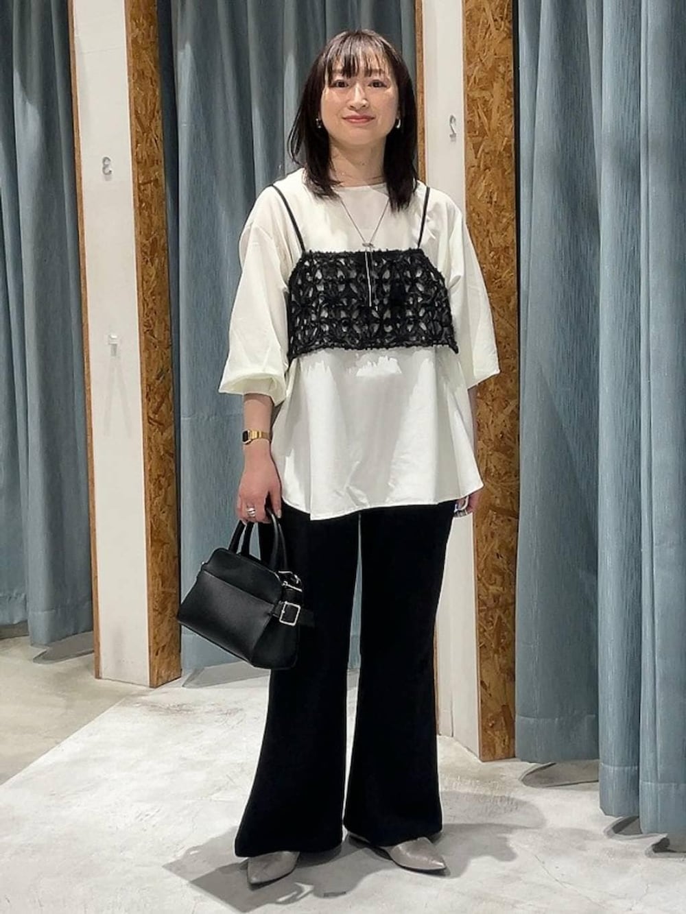 ブラック系のショルダーバッグ、シルバー系のパンプス、ホワイト系のシャツ/ブラウスを着用したレディースの冬コーディネートの4枚目の写真