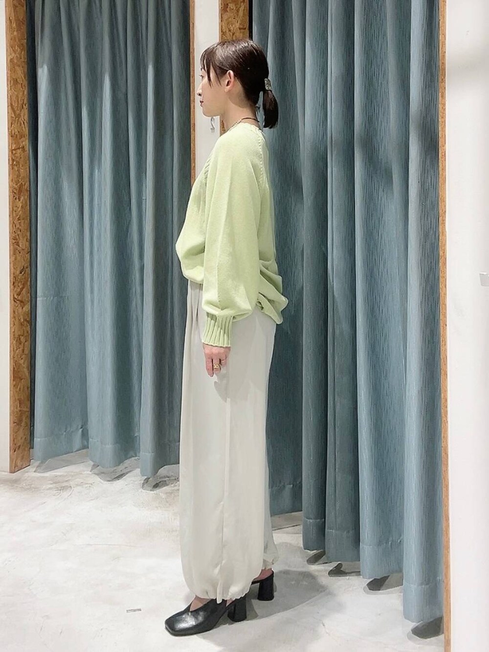 ホワイト系のその他パンツ、ブラック系のパンプス、グリーン系のニット/セーターを着用したレディースの冬コーディネートの4枚目の写真