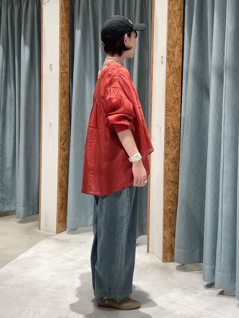 レッド系のシャツ/ブラウス、ベージュ系のパンプス、ブルー系のデニムパンツを着用したレディースの春コーディネートの3枚目の写真