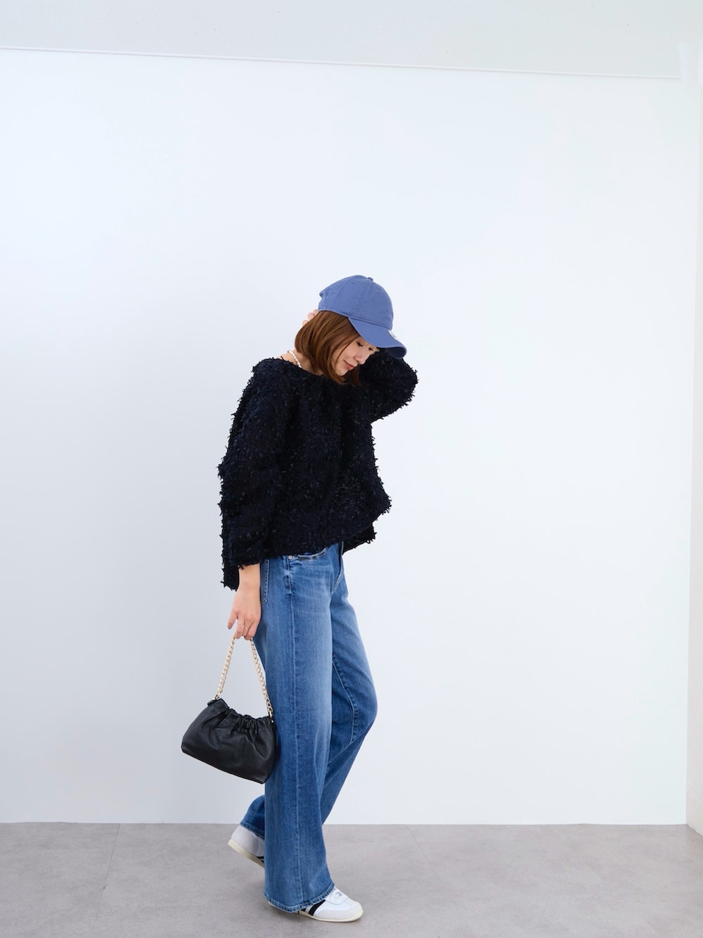 ブラック系のシャツ/ブラウス、ブルー系のキャップを着用したレディースの冬コーディネートの2枚目の写真