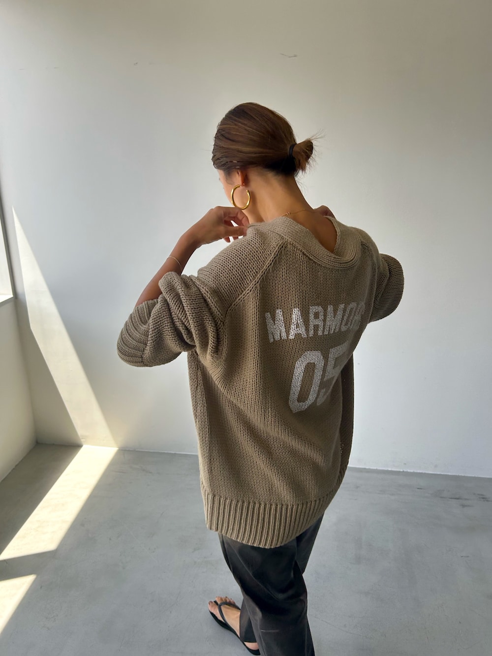 ベージュ系のニット/セーター、ブラック系のその他パンツを着用したレディースの秋コーディネートの3枚目の写真