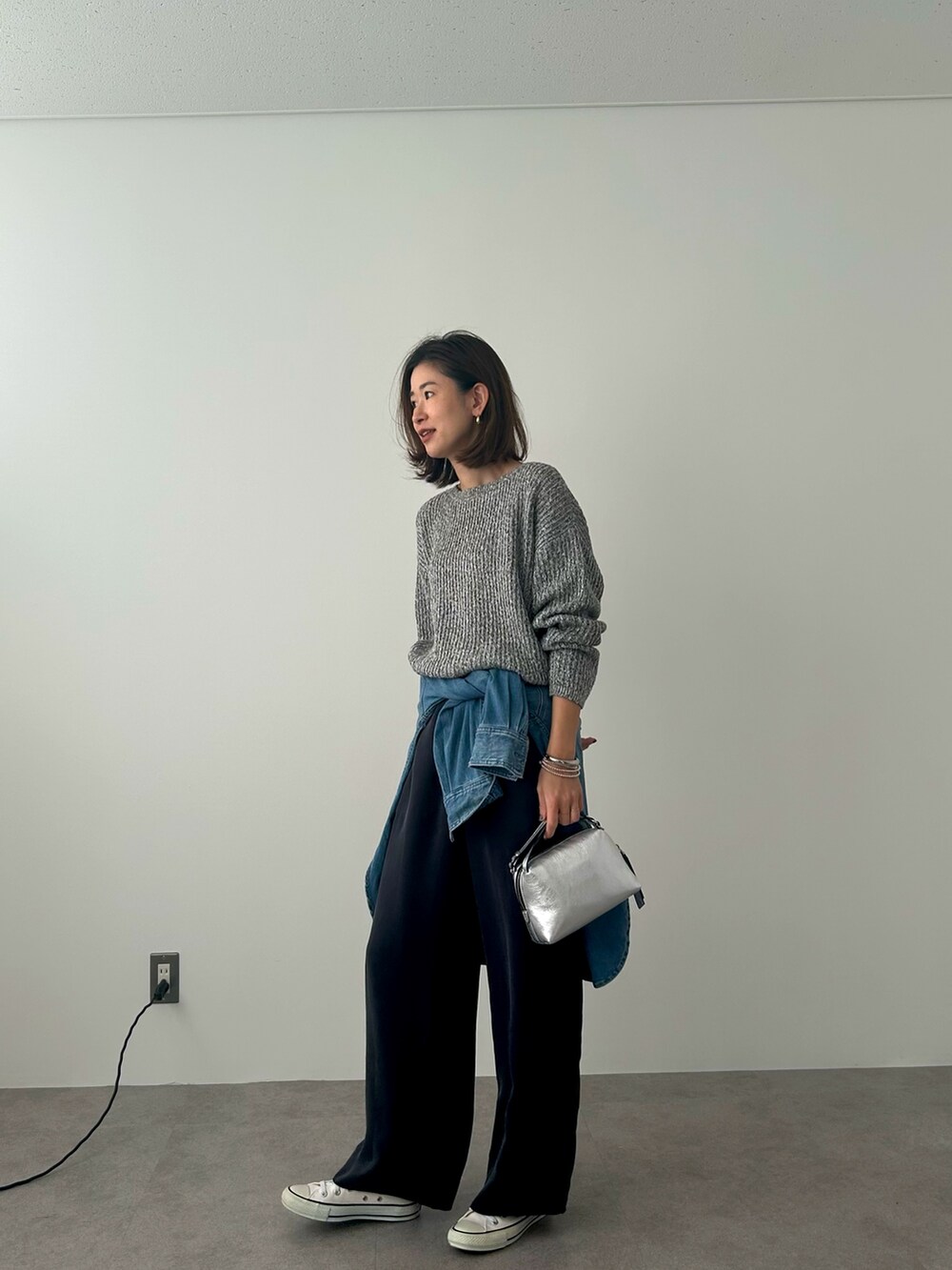 ブラック系のニット/セーター、ブルー系のシャツ/ブラウスを着用したレディースの冬コーディネートの2枚目の写真