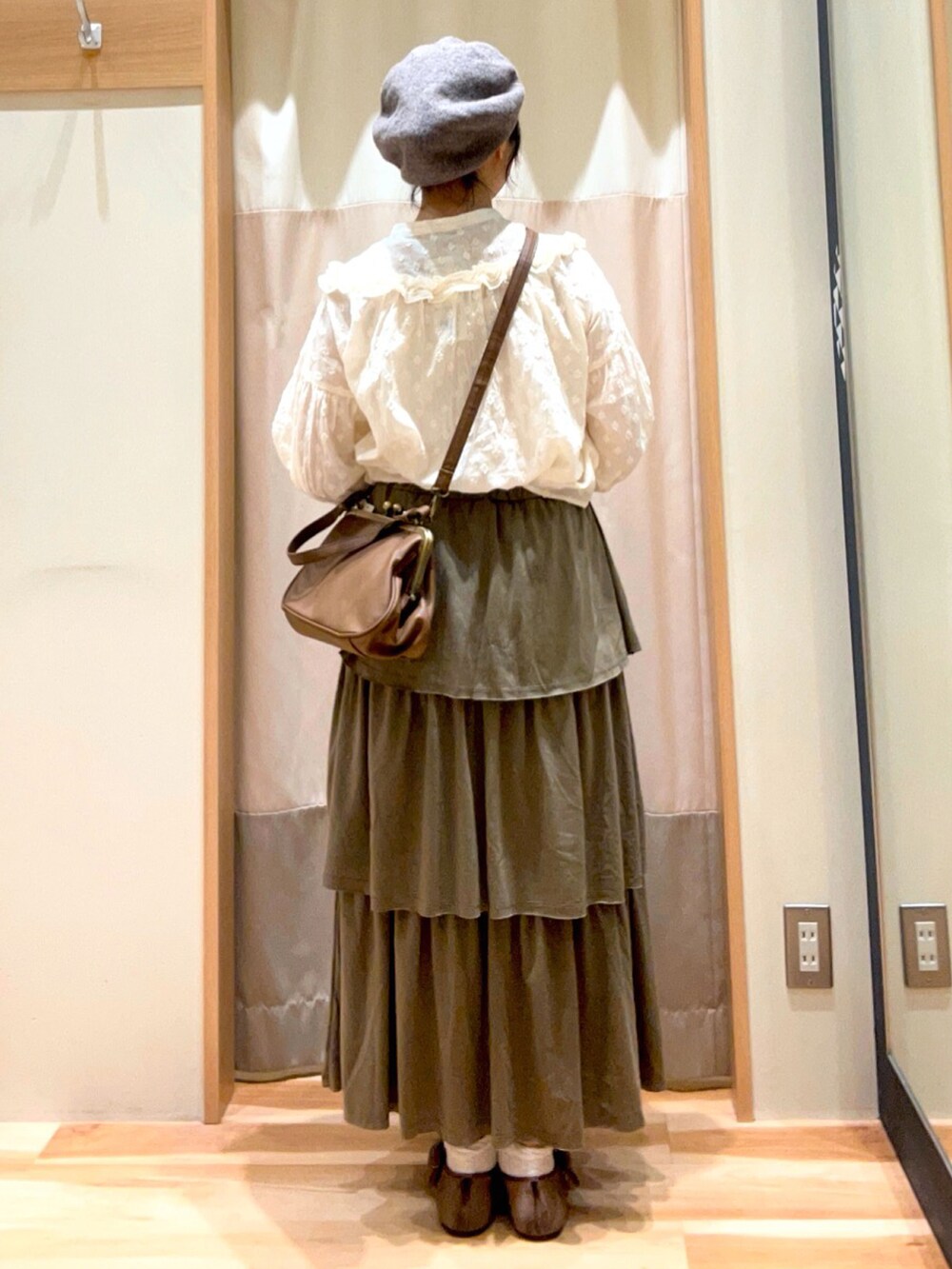 グリーン系のスカート、ホワイト系のシャツ/ブラウス、ブラウン系のドレスシューズを着用したレディースの夏コーディネートの3枚目の写真