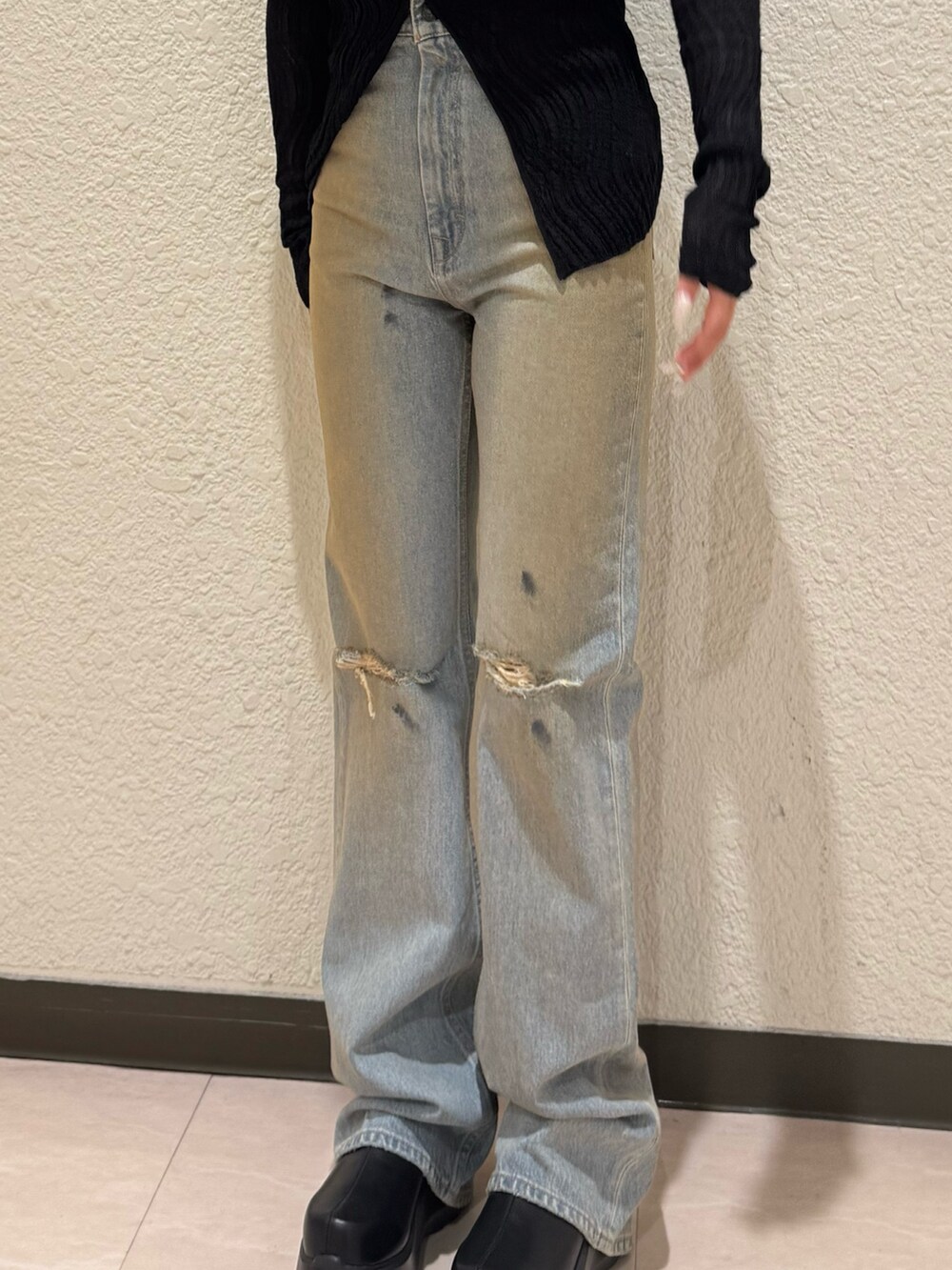 ブルー系のデニムパンツ、ブラック系のブーツ、ブラック系のニット/セーターを着用したレディースの春コーディネートの4枚目の写真