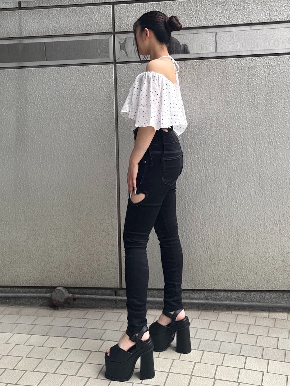 ブラック系のデニムパンツ、ホワイト系のTシャツ/カットソー、ブラック系のサンダルを着用したレディースの夏コーディネートの2枚目の写真