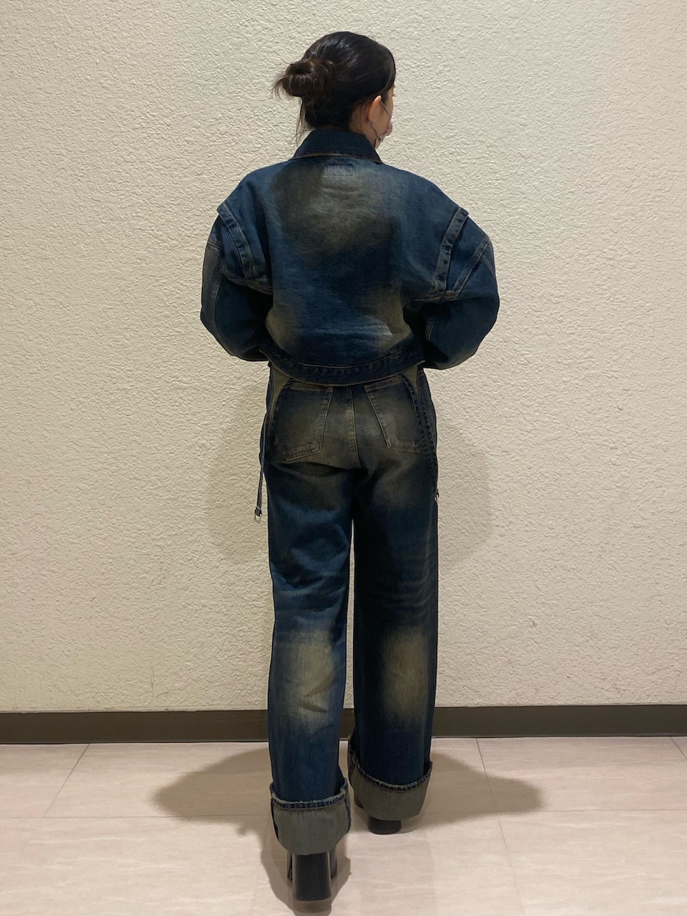 ブルー系のデニムパンツ、ブルー系のデニムジャケット、ブラック系のブーツを着用したレディースの秋コーディネートの3枚目の写真