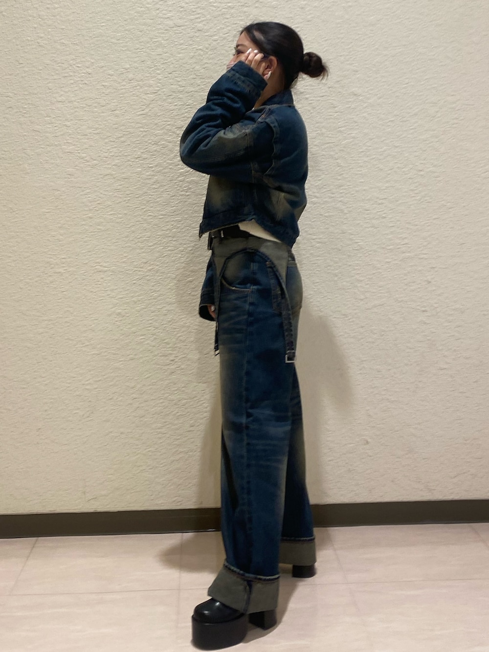 ブルー系のデニムパンツ、ブルー系のデニムジャケット、ブラック系のブーツを着用したレディースの秋コーディネートの2枚目の写真