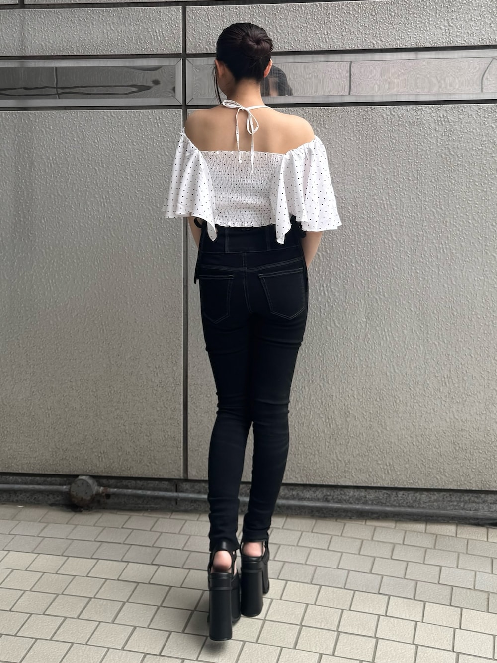 ブラック系のデニムパンツ、ホワイト系のTシャツ/カットソー、ブラック系のサンダルを着用したレディースの夏コーディネートの3枚目の写真