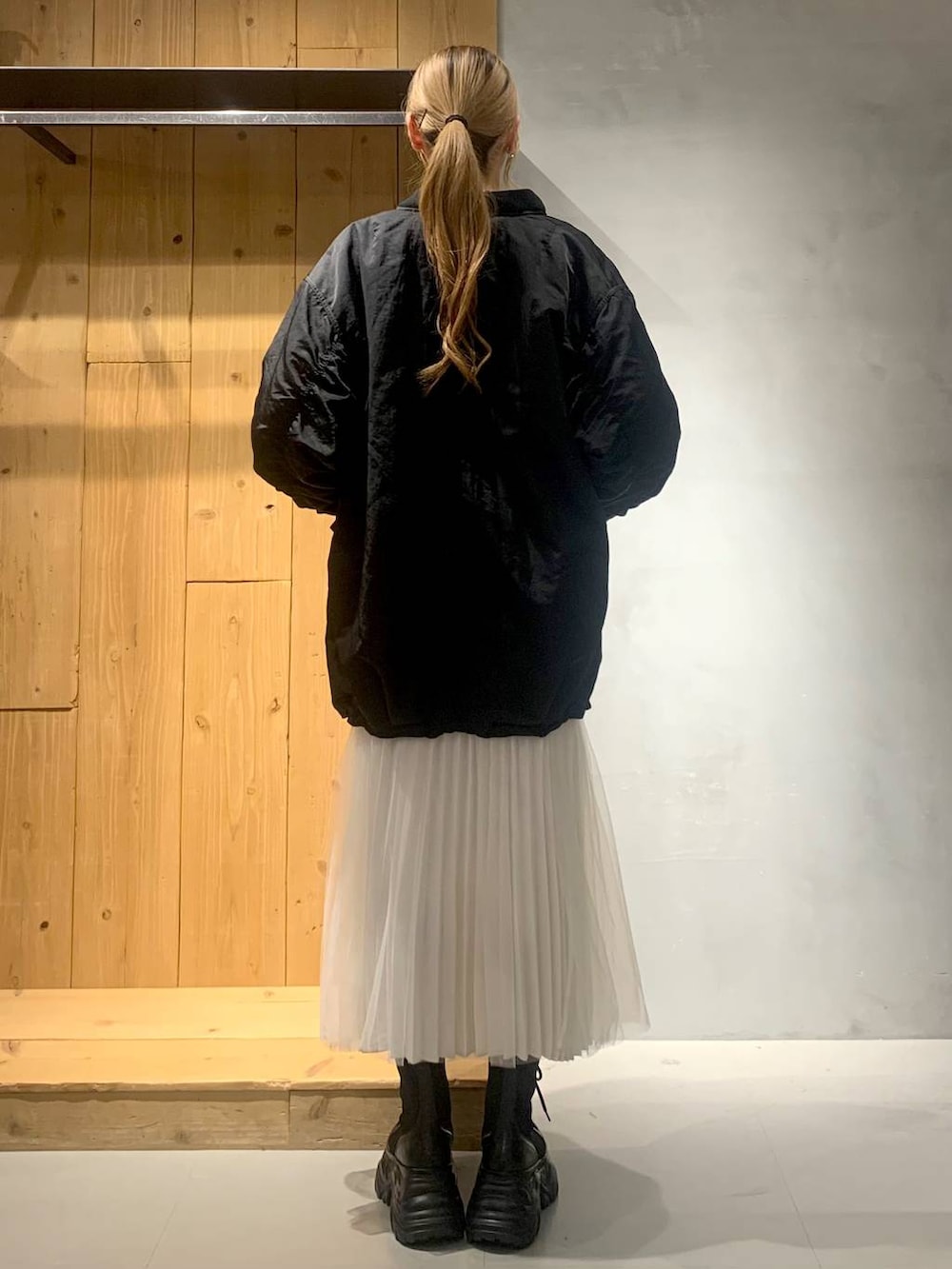 ブラック系のブーツ、ブラック系のブルゾン、ブルー系のスウェットを着用したレディースの秋コーディネートの3枚目の写真