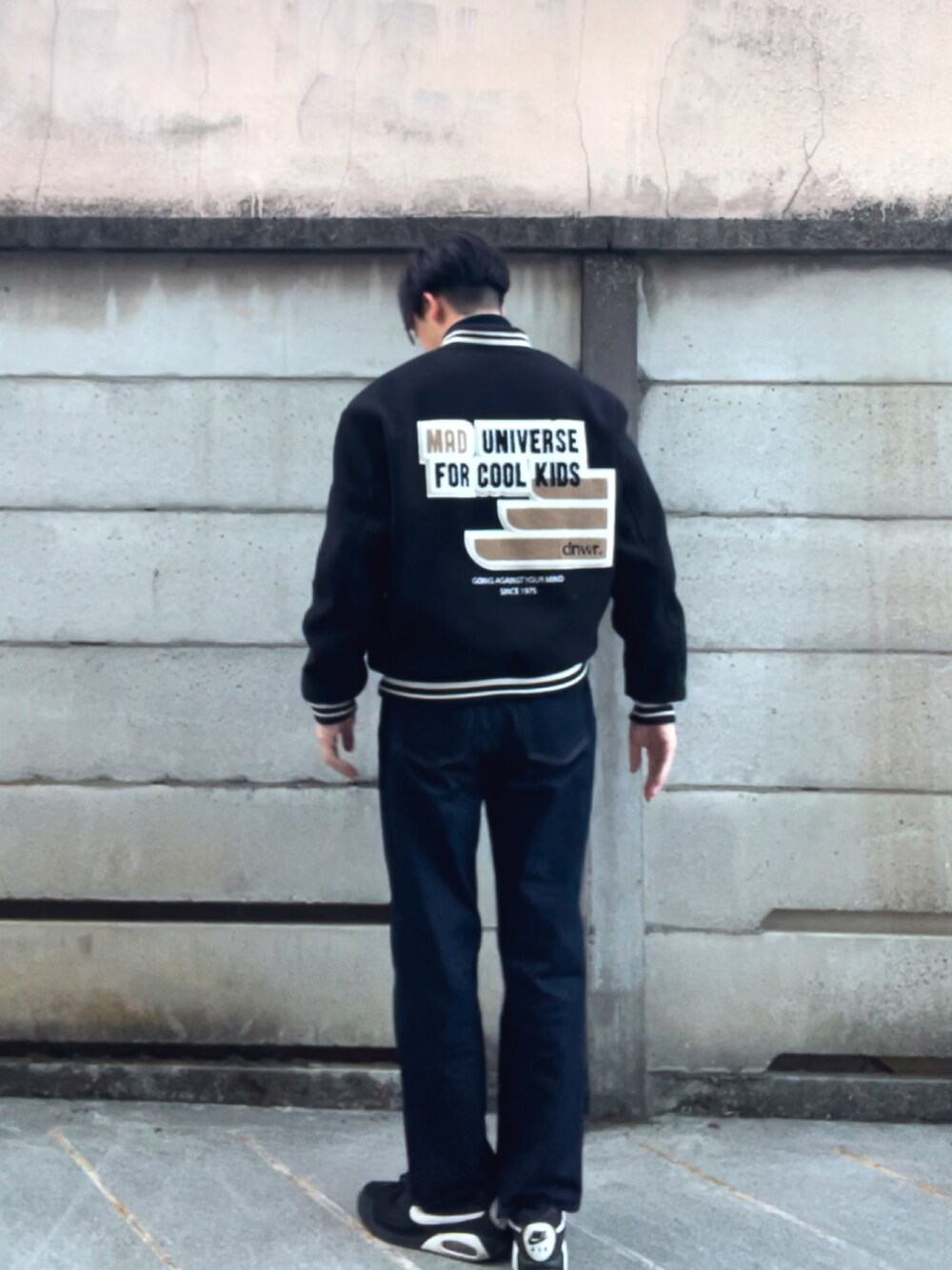 ブラック系のジャケット/アウター、ブルー系のニット/セーター、ブラック系のデニムパンツを着用したメンズの春コーディネートの2枚目の写真