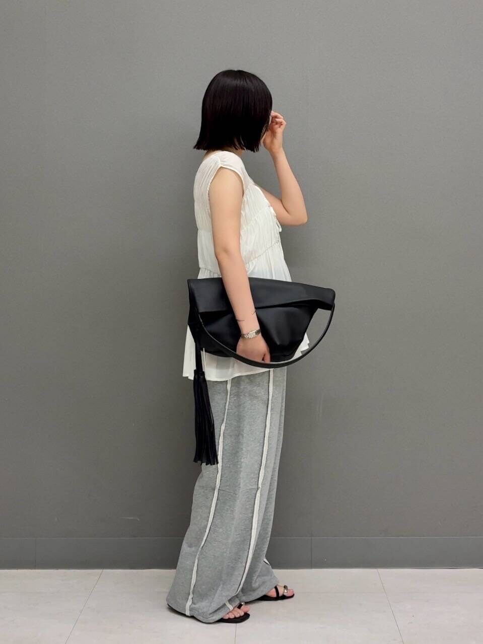 ブラック系のトートバッグ、ホワイト系のシャツ/ブラウス、グレー系のその他パンツを着用したレディースの夏コーディネートの3枚目の写真