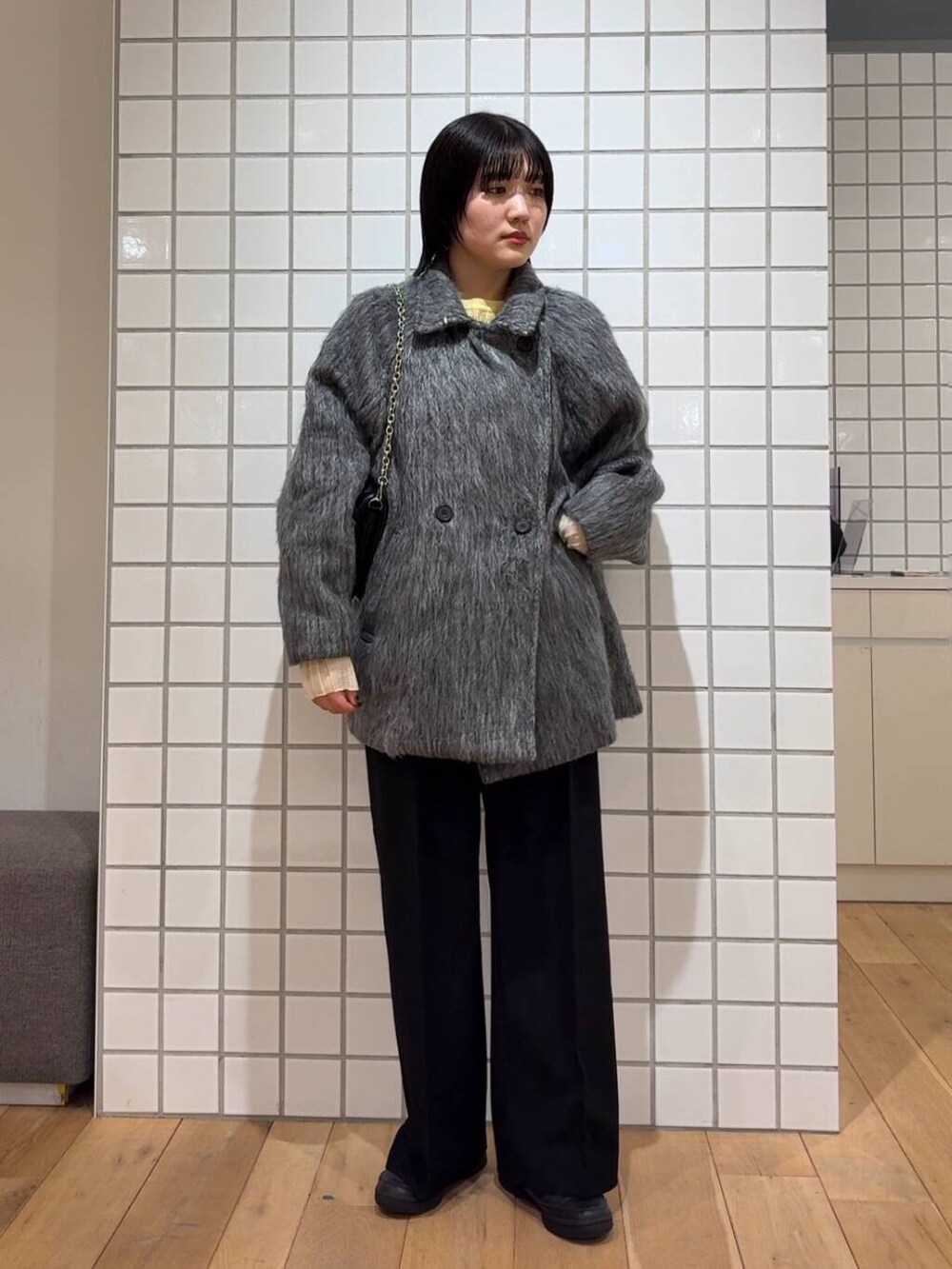 ブラック系のその他パンツ、イエロー系のニット/セーター、ブラック系のショルダーバッグを着用したレディースの冬コーディネートの2枚目の写真