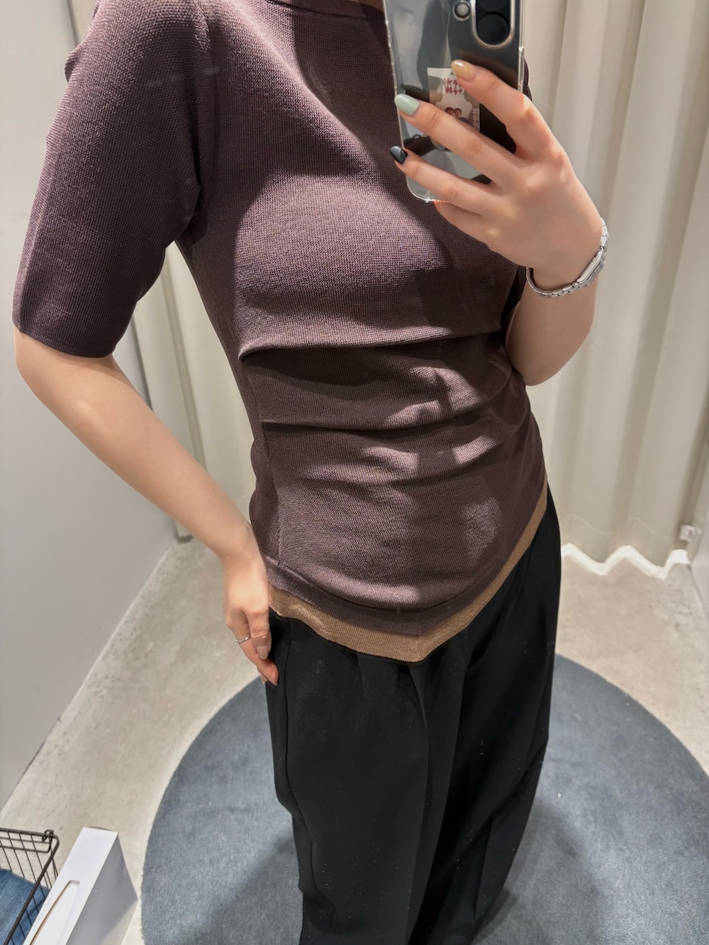 ブラウン系のニット/セーター、ブラック系のスラックスを着用したレディースの春コーディネートの3枚目の写真