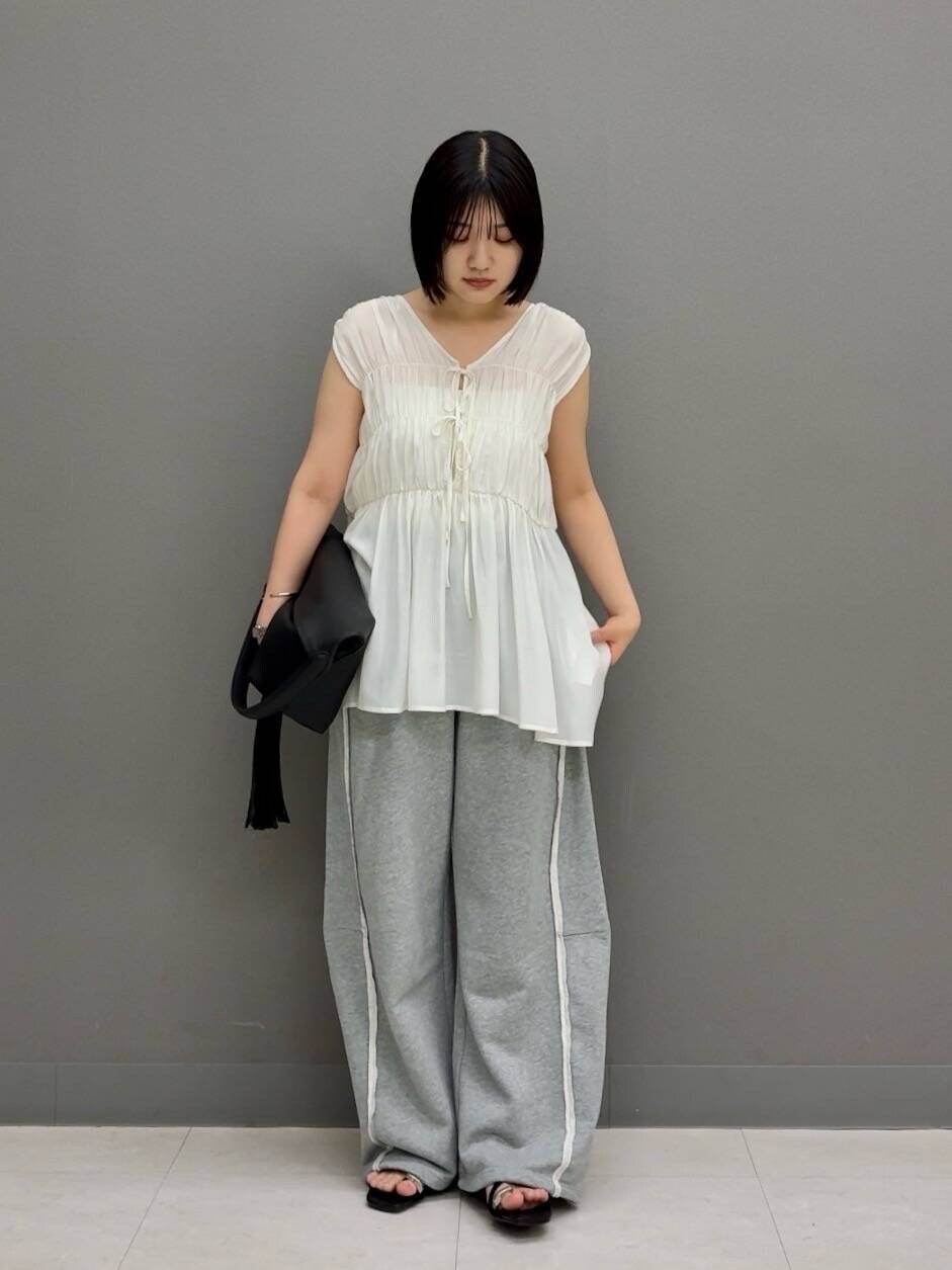 ブラック系のトートバッグ、ホワイト系のシャツ/ブラウス、グレー系のその他パンツを着用したレディースの夏コーディネートの2枚目の写真