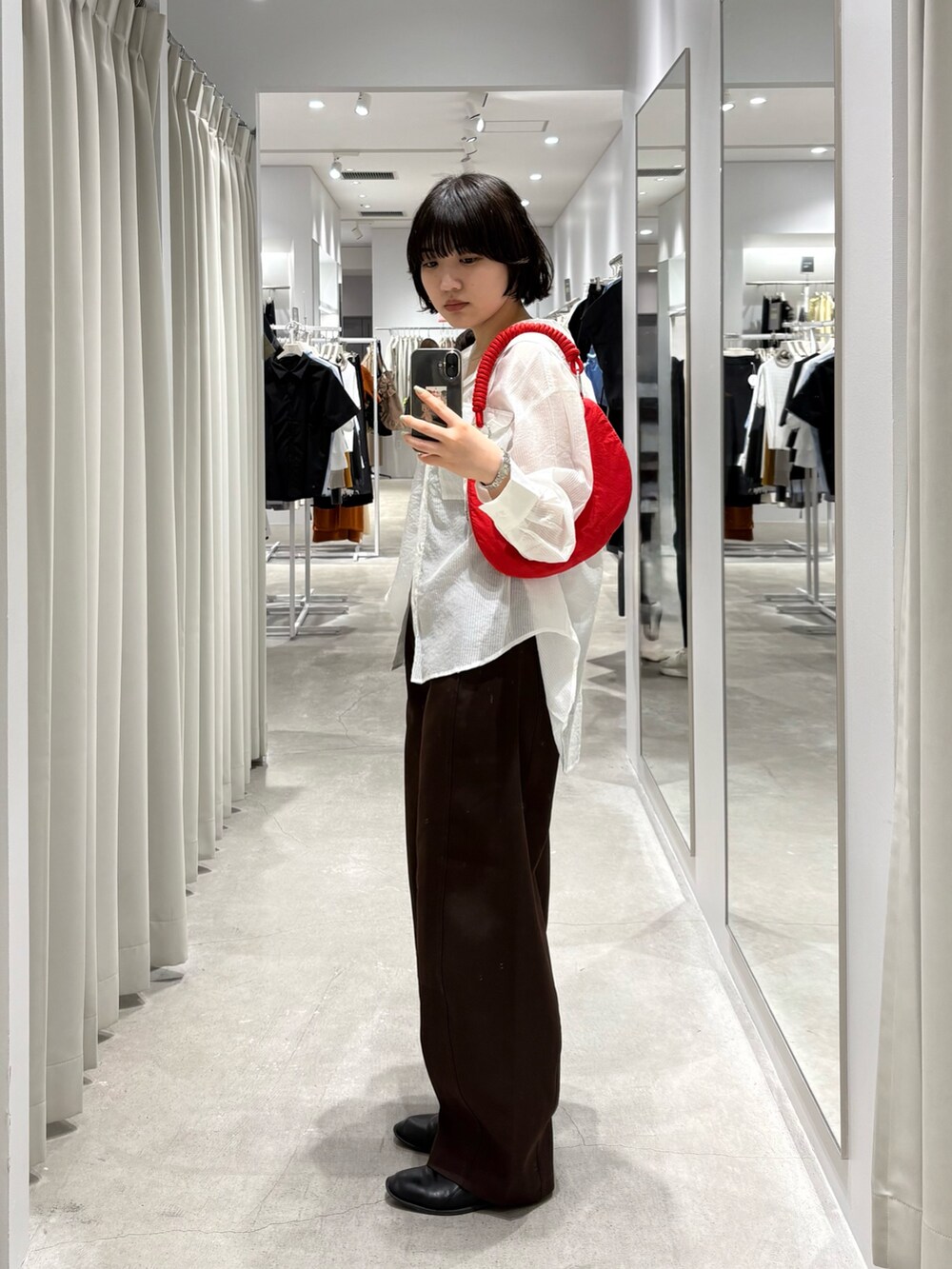 レッド系のハンドバッグ、ホワイト系のシャツ/ブラウス、ブラウン系のその他パンツを着用したレディースの春コーディネートの3枚目の写真