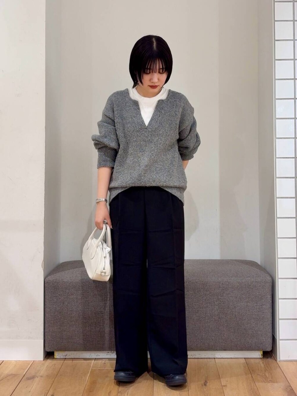 ブラック系のその他パンツ、ホワイト系のボストンバッグ、グレー系のニット/セーターを着用したレディースの冬コーディネートの2枚目の写真