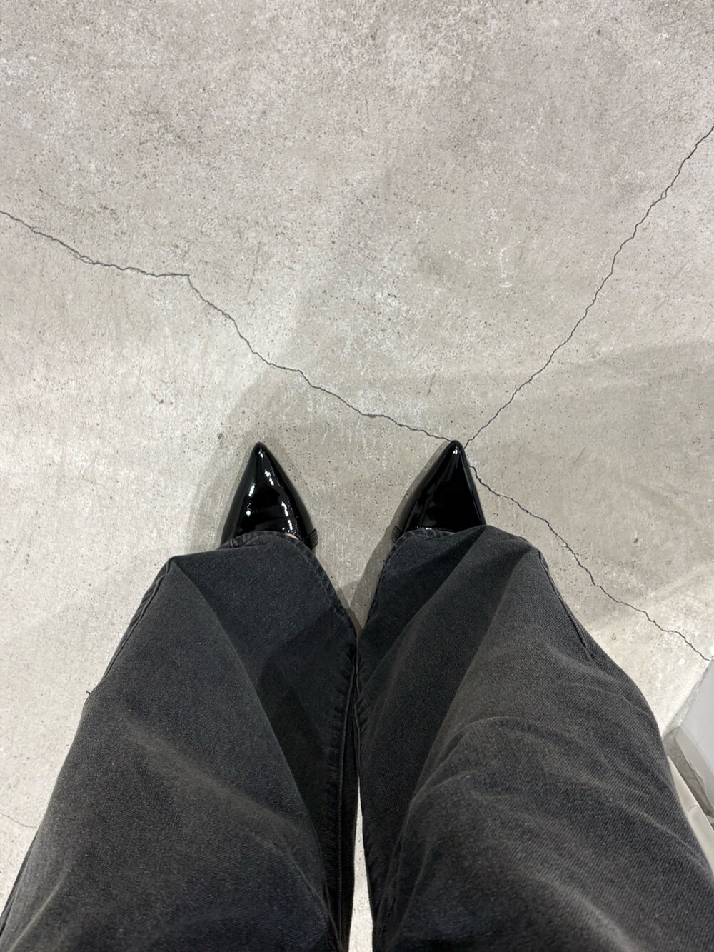 ブラック系のカーディガン/ボレロ、グレー系のデニムパンツ、ブラック系のパンプスを着用したレディースの春コーディネートの4枚目の写真
