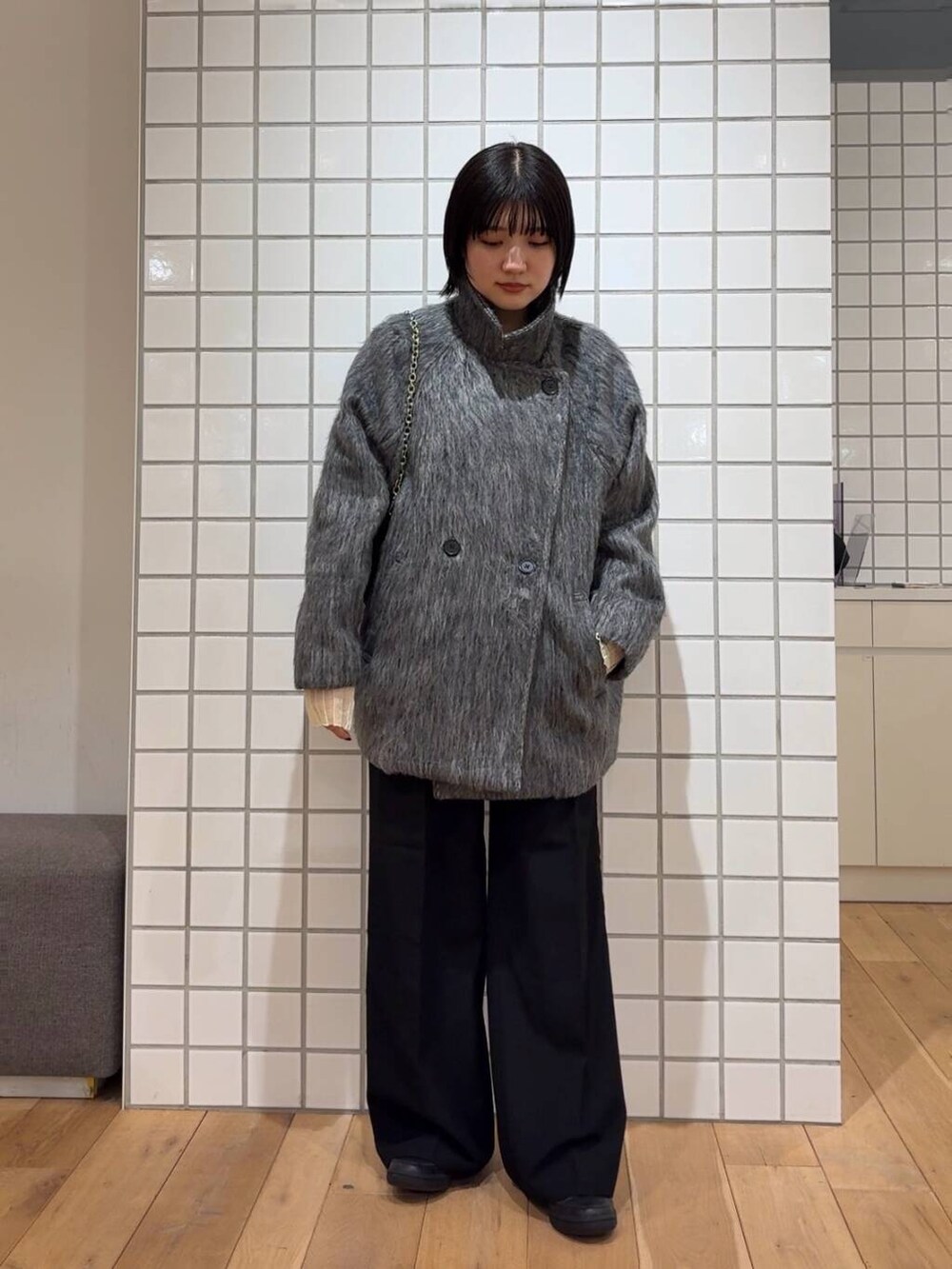 ブラック系のその他パンツ、イエロー系のニット/セーター、ブラック系のショルダーバッグを着用したレディースの冬コーディネートの3枚目の写真