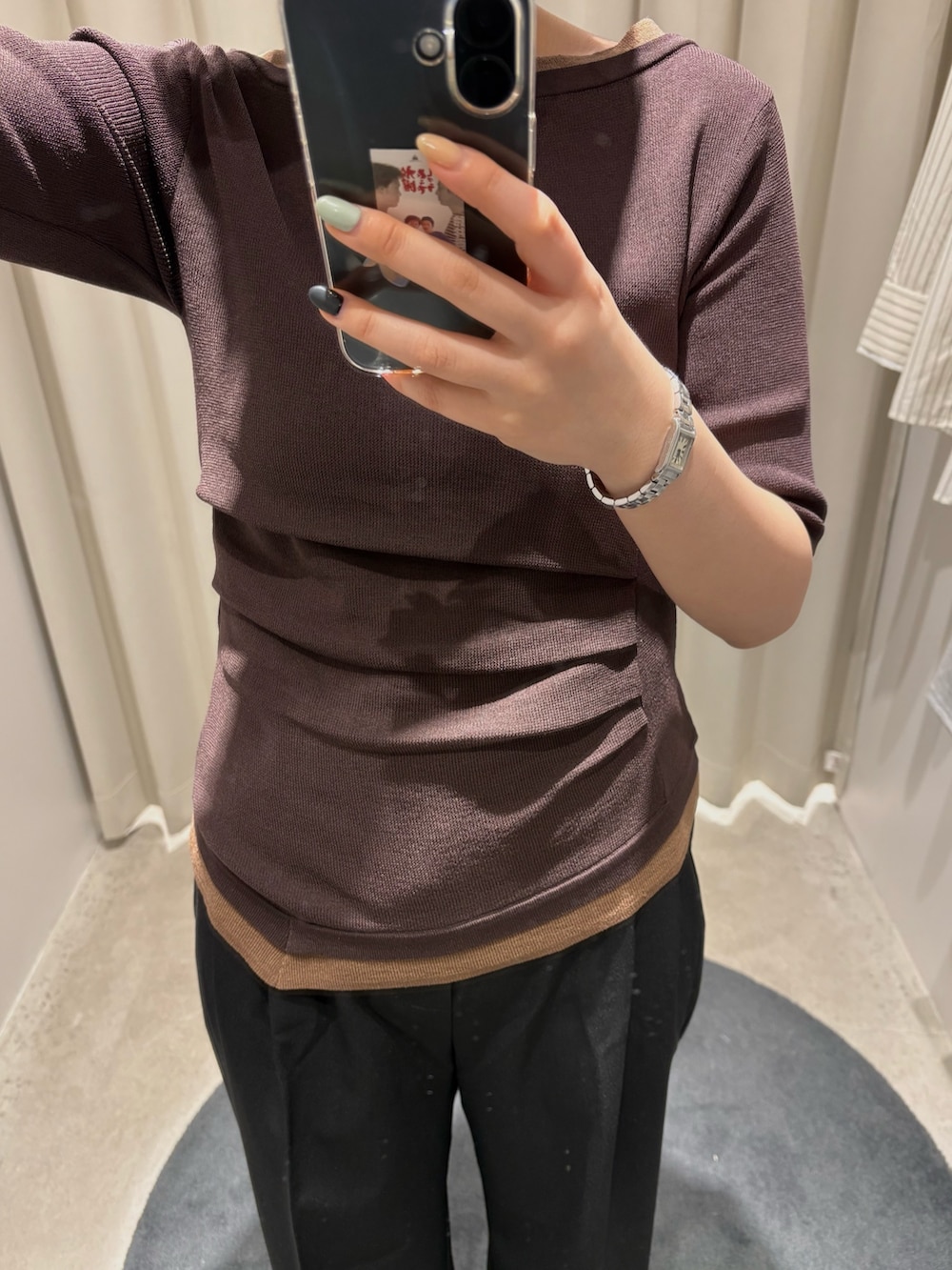 ブラウン系のニット/セーター、ブラック系のスラックスを着用したレディースの春コーディネートの2枚目の写真