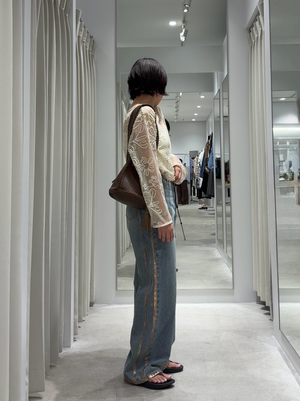 ホワイト系のTシャツ/カットソー、ブルー系のデニムパンツ、ブラウン系のショルダーバッグを着用したレディースの秋コーディネートの2枚目の写真