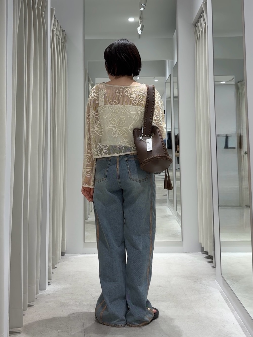 ホワイト系のTシャツ/カットソー、ブルー系のデニムパンツ、ブラウン系のショルダーバッグを着用したレディースの秋コーディネートの3枚目の写真