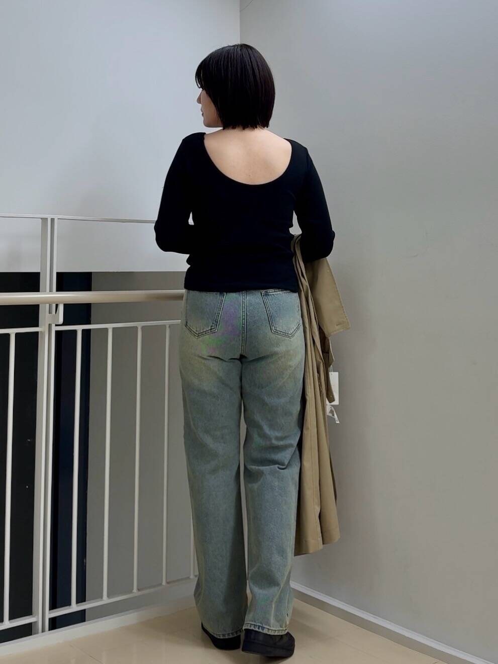 ブルー系のデニムパンツ、ベージュ系のトレンチコート、ブラック系のTシャツ/カットソーを着用したレディースの春コーディネートの4枚目の写真