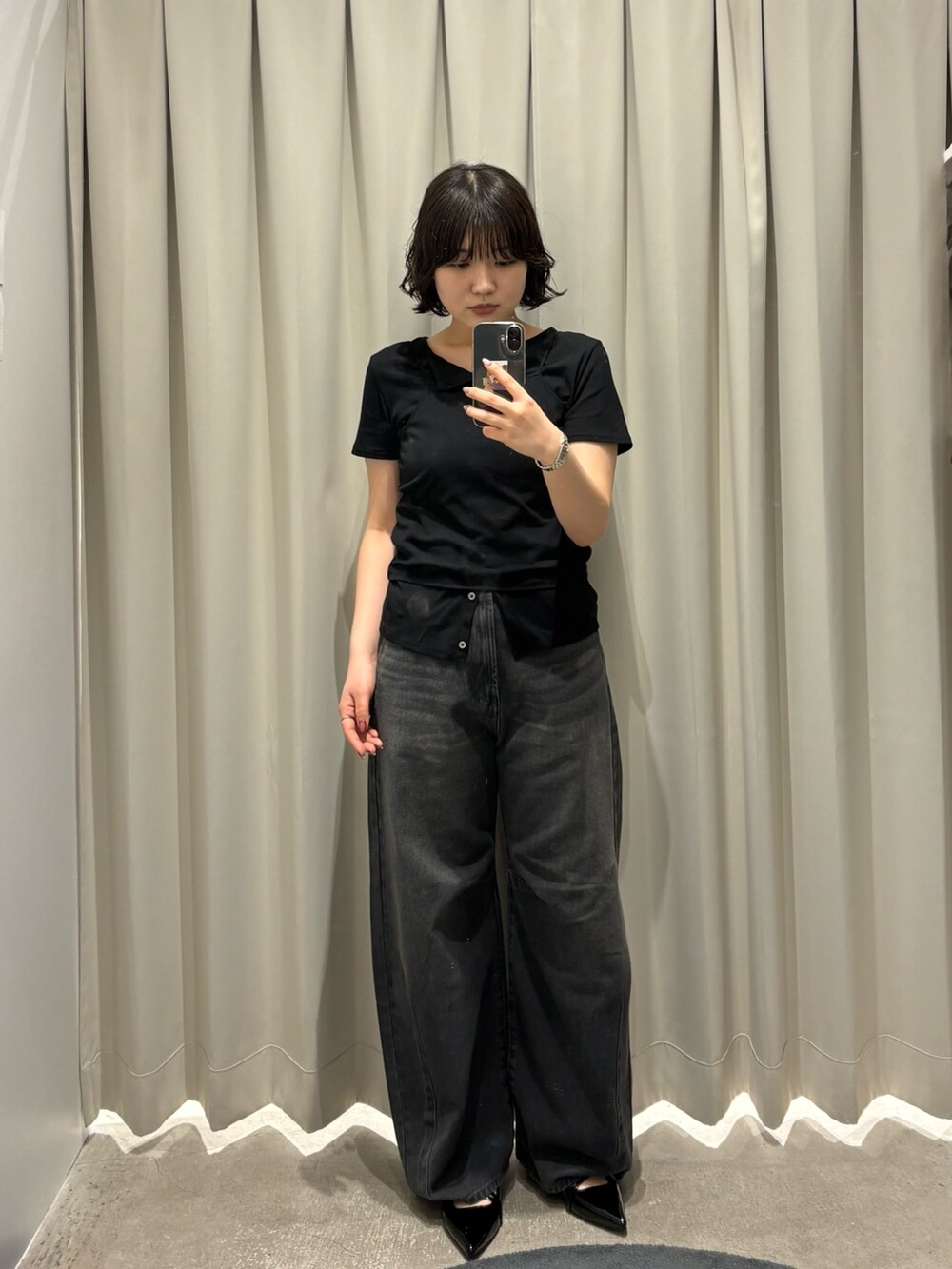 ブラック系のカーディガン/ボレロ、グレー系のデニムパンツ、ブラック系のパンプスを着用したレディースの春コーディネートの2枚目の写真