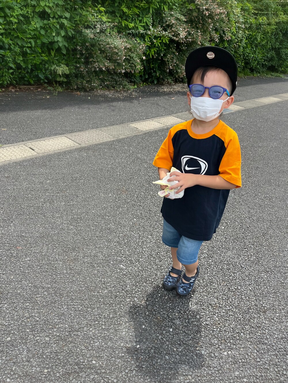 オレンジ系のTシャツ/カットソー、ブルー系のデニムパンツ、ブルー系のサンダルを着用したキッズの夏コーディネートの2枚目の写真