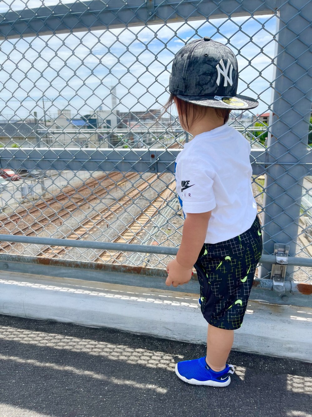 ブラック系のパンツ、ホワイト系のTシャツ/カットソー、ブルー系のサンダルを着用したキッズの夏コーディネートの2枚目の写真