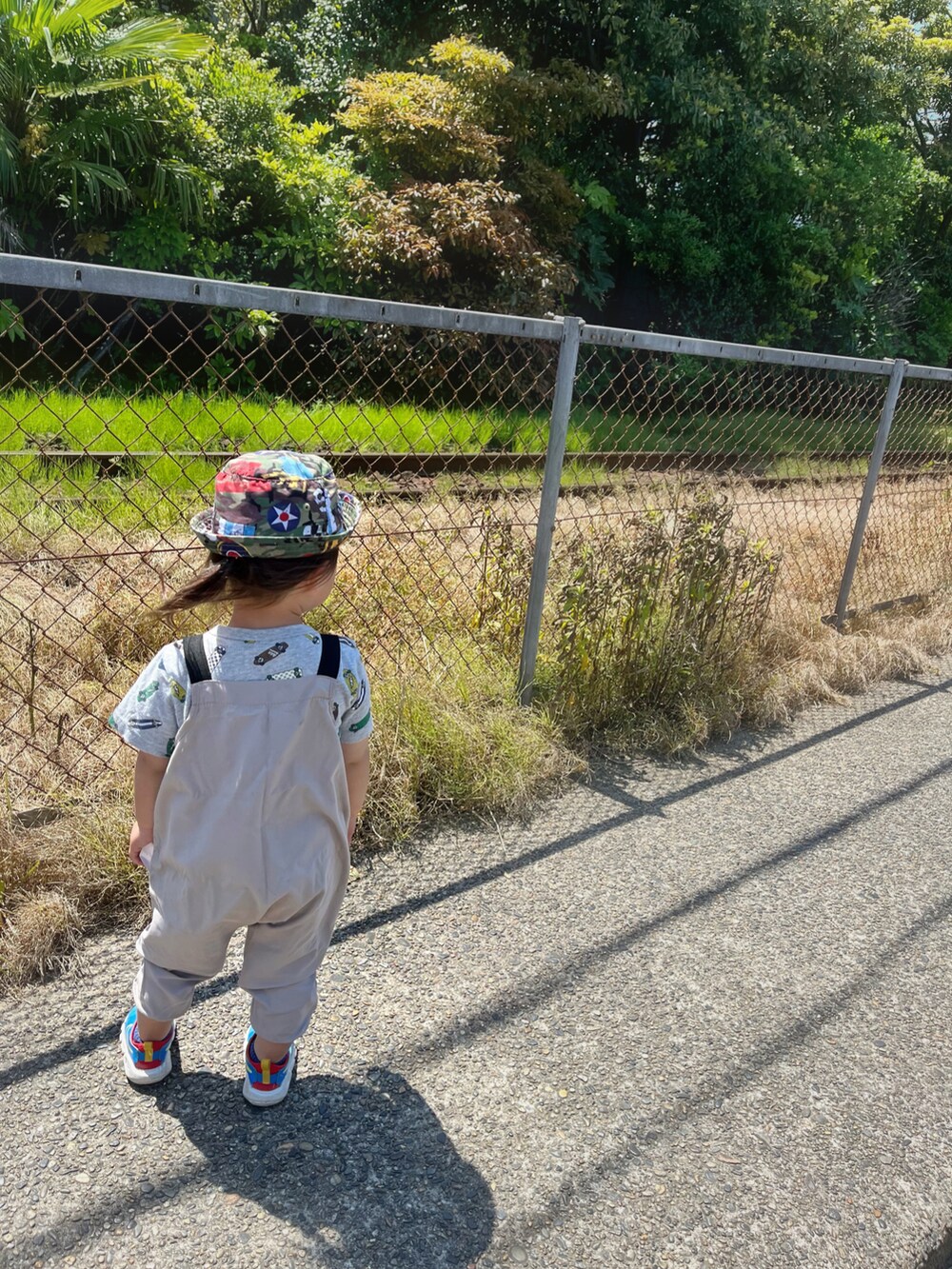 ベージュ系のオールインワン・サロペット、グレー系のスニーカー、ブルー系のスニーカーを着用したキッズの春コーディネートの2枚目の写真