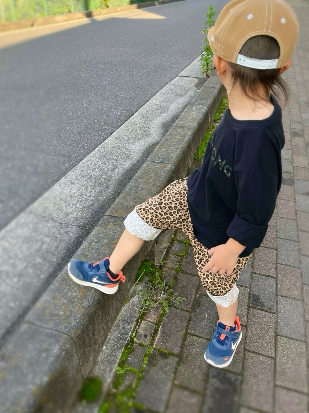 ブラック系のTシャツ/カットソー、ゴールド系のその他パンツ、ブルー系のスニーカーを着用したキッズの秋コーディネートの3枚目の写真