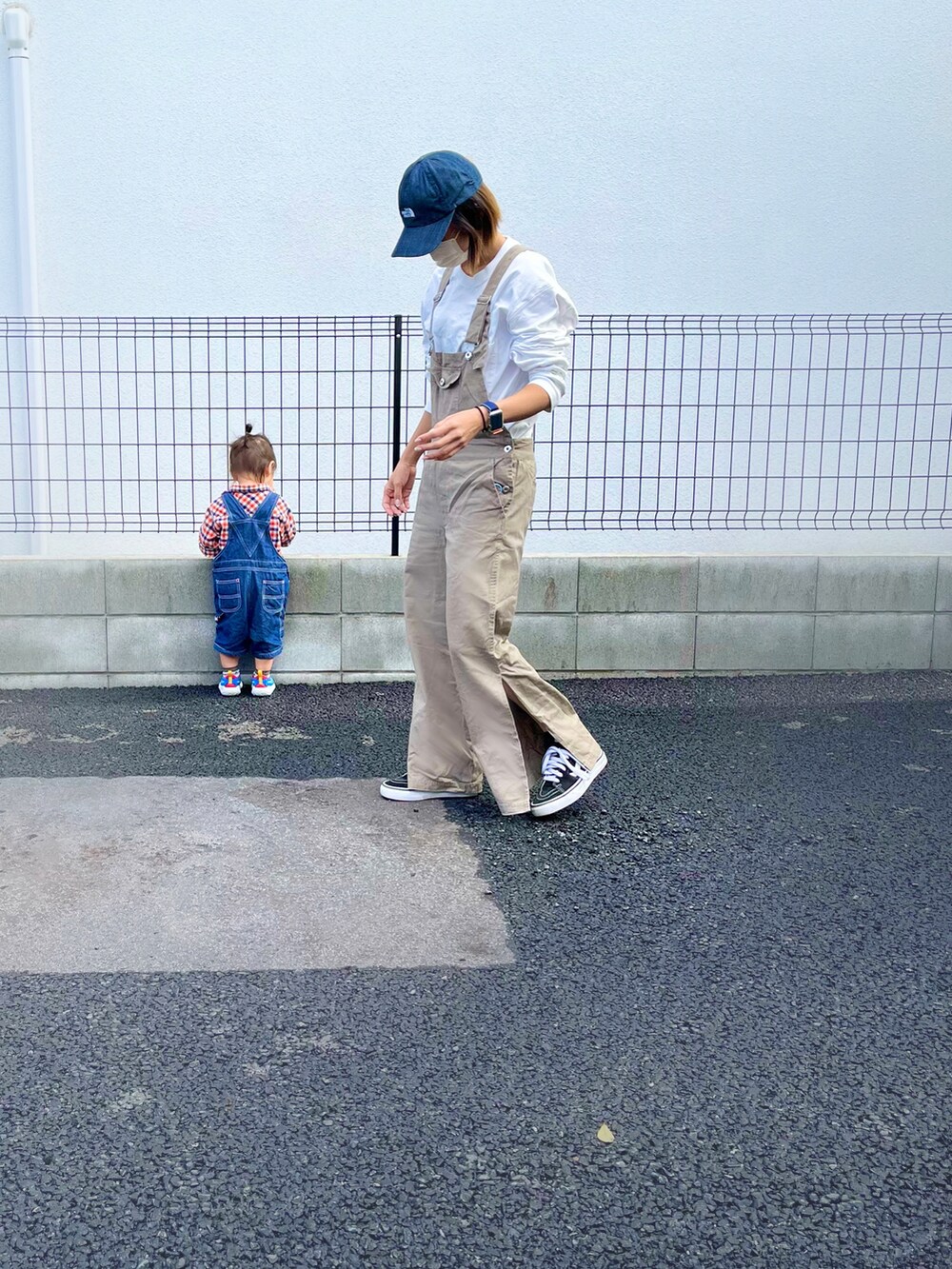 ホワイト系のTシャツ/カットソー、ベージュ系のオールインワン・サロペット、ブラック系のスニーカーを着用したレディースの秋コーディネートの2枚目の写真