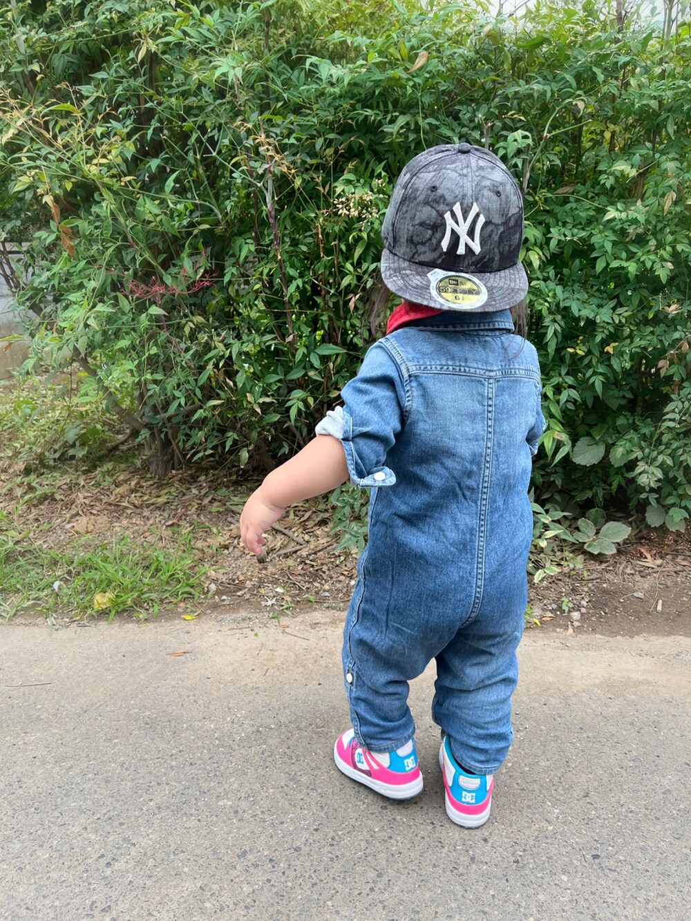 ブルー系のつなぎ/オールインワン、ピンク系のスニーカー、ブラック系のキャップを着用したキッズの夏コーディネートの2枚目の写真