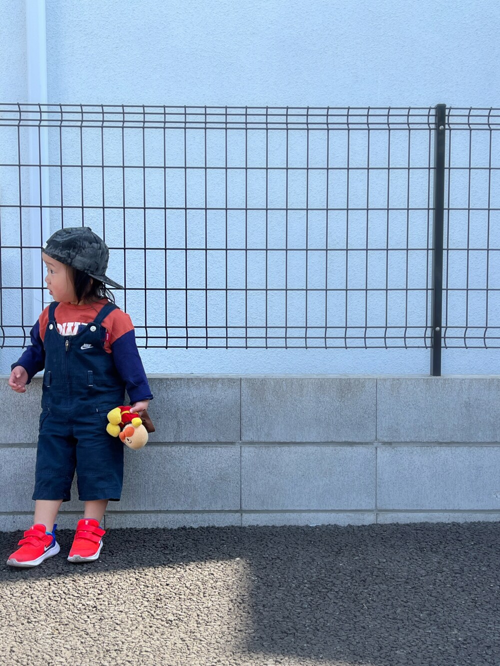 オレンジ系のTシャツ/カットソー、ブルー系のオールインワン・サロペット、オレンジ系のスニーカーを着用したキッズの春コーディネートの3枚目の写真