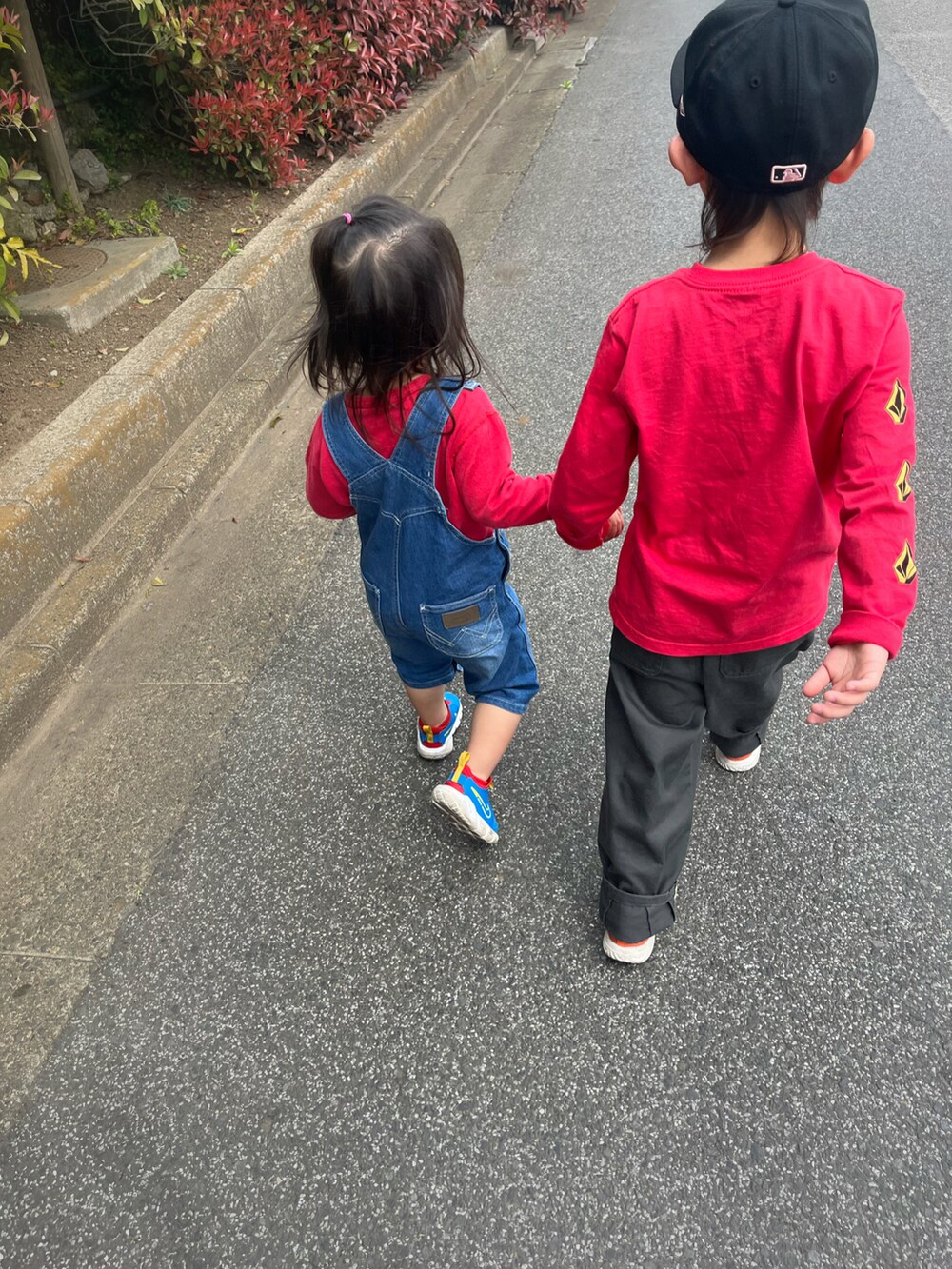 レッド系のトップス、グリーン系のパンツ、ブルー系のスニーカーを着用したキッズの春コーディネートの2枚目の写真