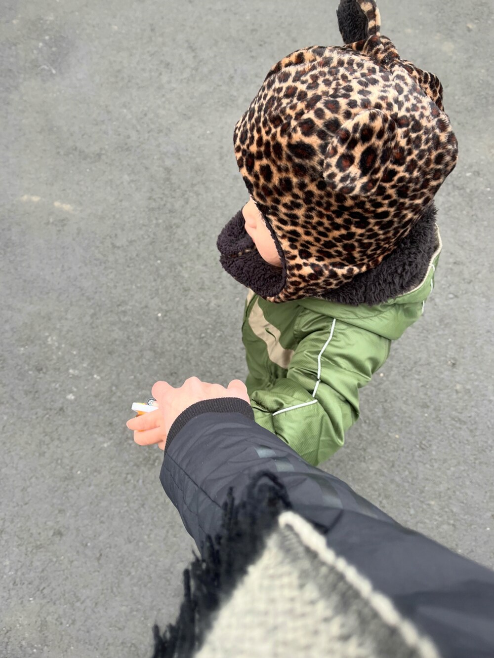 グリーン系のカバーオール、ブルー系のスニーカー、ブラウン系の帽子を着用したキッズの冬コーディネートの3枚目の写真