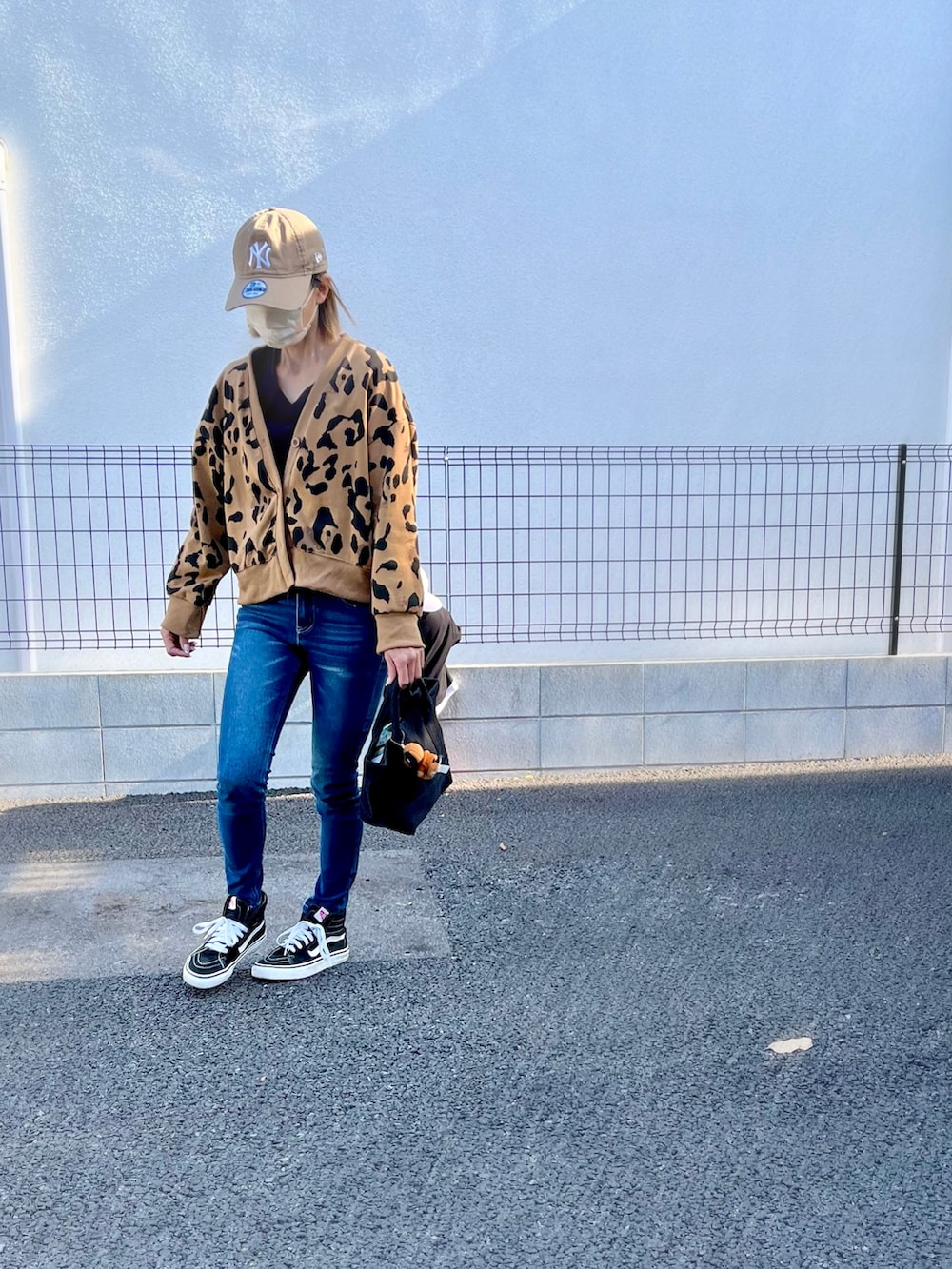 ブラウン系のカーディガン/ボレロ、ブルー系のデニムパンツ、ブラック系のスニーカーを着用したレディースの秋コーディネートの2枚目の写真