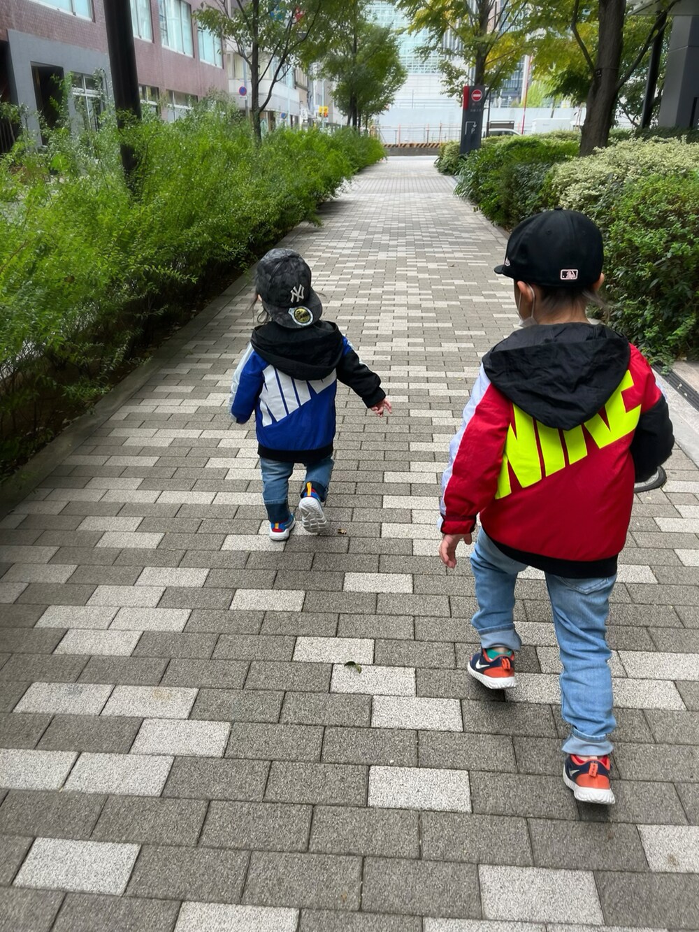 ブラック系のナイロンジャケット、レッド系のジャケット/アウター、ブルー系のその他アウターを着用したキッズの秋コーディネートの2枚目の写真