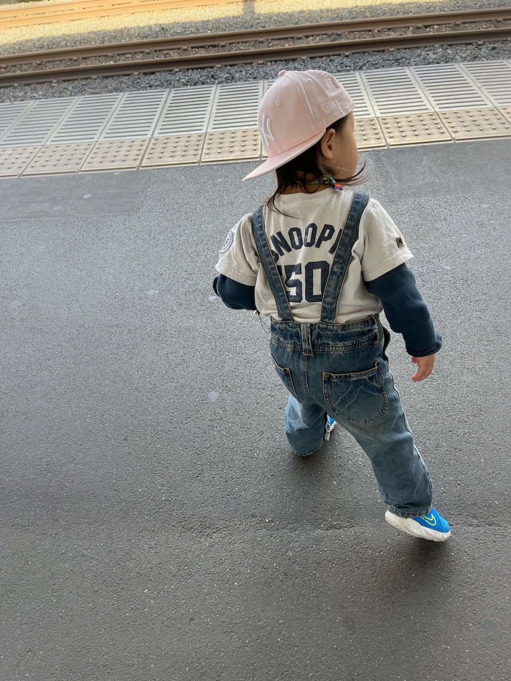 ブルー系のトップス、ブルー系のスニーカー、ピンク系のキャップを着用したキッズの春コーディネートの3枚目の写真