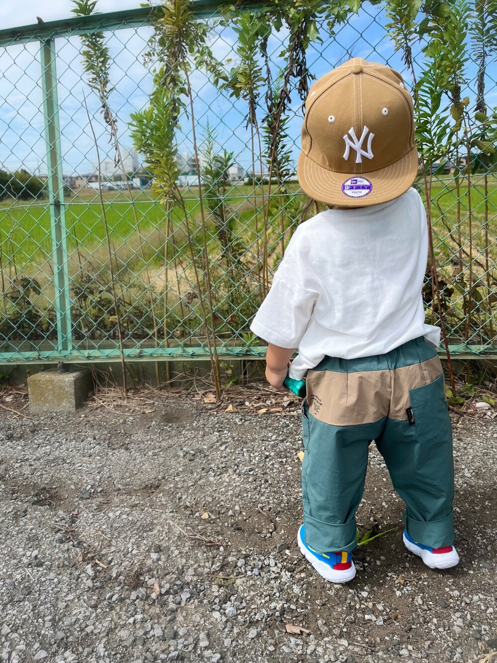 グリーン系のその他パンツ、ブルー系のスニーカー、オレンジ系のシャツ/ブラウスを着用したキッズの秋コーディネートの3枚目の写真