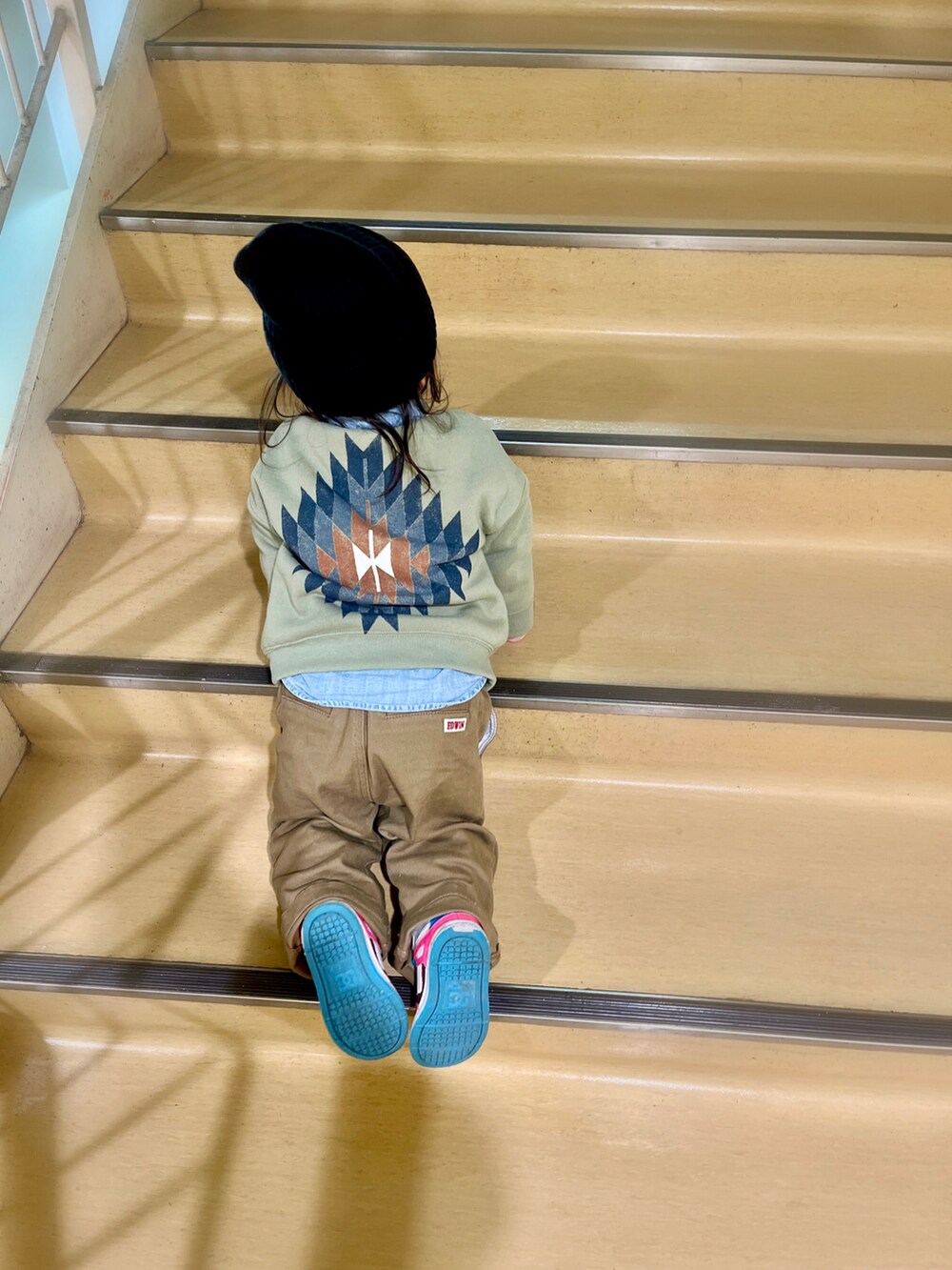 グリーン系のスウェット、ベージュ系のデニムパンツ、ブルー系のシャツ/ブラウスを着用したキッズの冬コーディネートの2枚目の写真