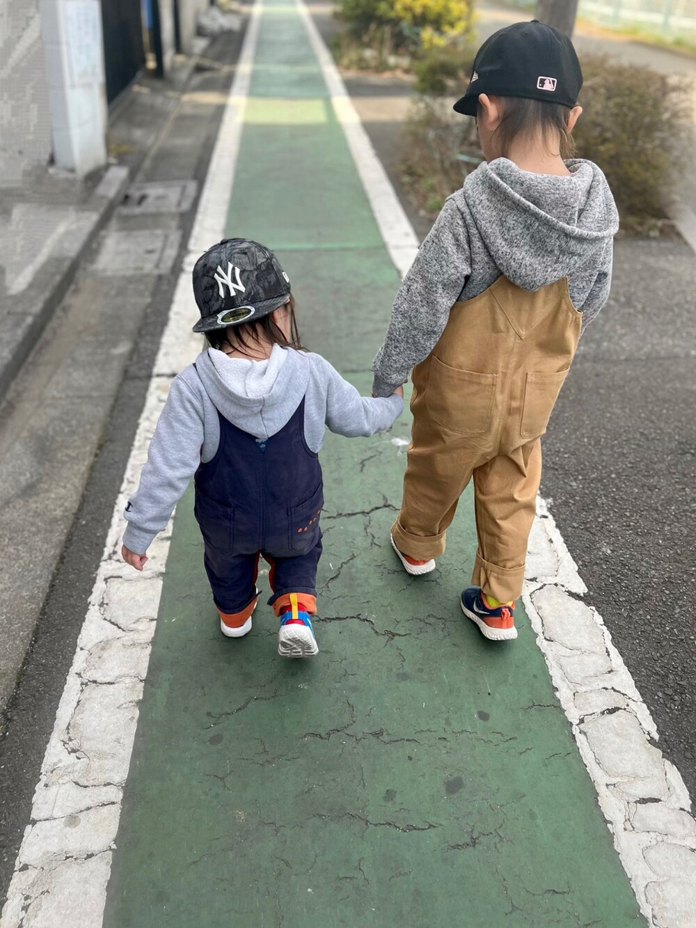 グレー系のパーカー、ブラウン系のオールインワン・サロペット、ブルー系のサロペット/オーバーオールを着用したキッズの春コーディネートの4枚目の写真