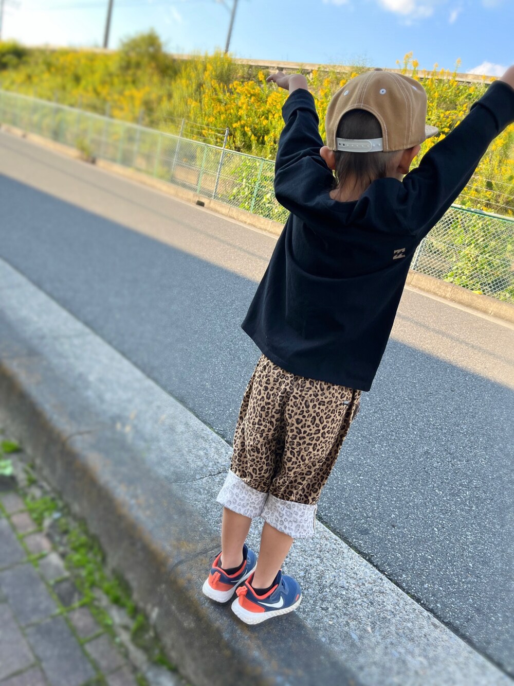 ブラック系のTシャツ/カットソー、ゴールド系のその他パンツ、ブルー系のスニーカーを着用したキッズの秋コーディネートの2枚目の写真
